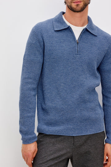 Monty is a collared quarter-zip long sleeved sweater in Cerulean Melange colorway. Front detail view featured on model.