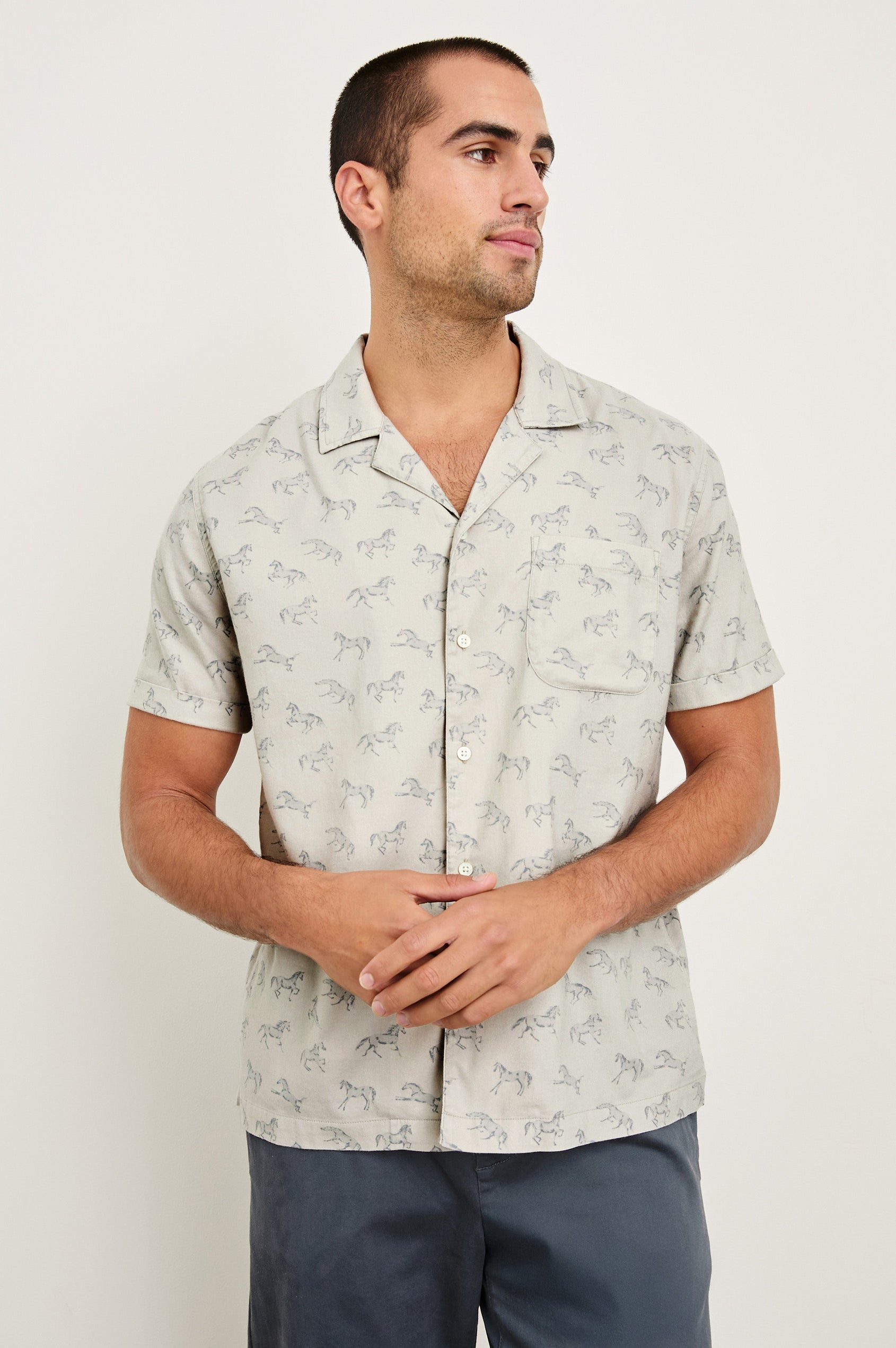 Moreno short sleeve button up shirt with camp collar and chest pocket in Stallion Parchment Indigo pattern - front view on model, hands in front