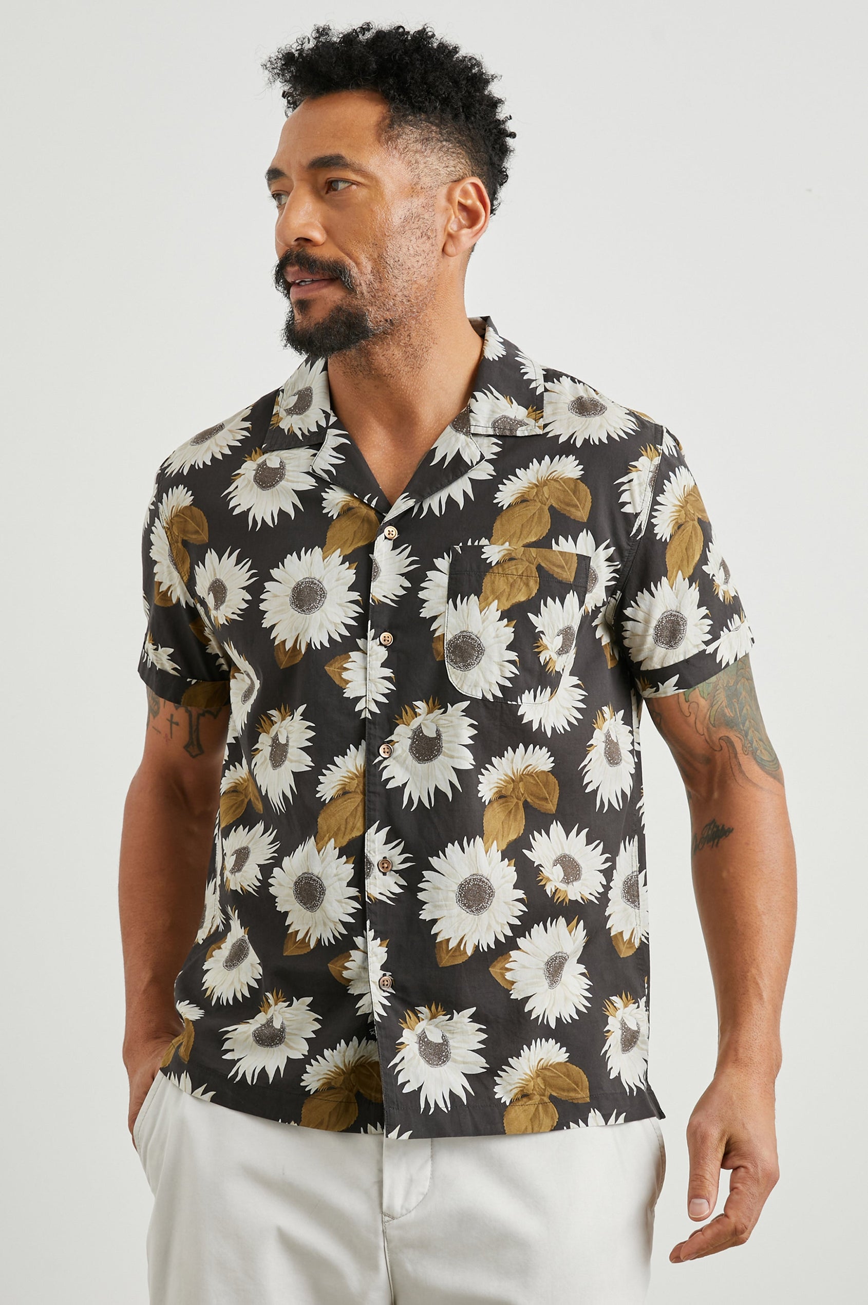 Moreno Short Sleeve Button Up with a Chest Patch Pocket in Sunflower Twirl Bark Colorway, White Sunflowers and Brown Leaves on Black  - Front View Featured on Model