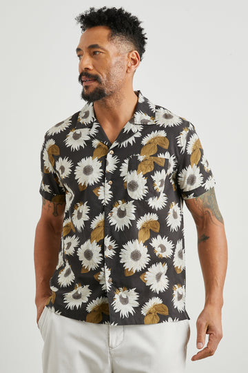 Moreno Short Sleeve Button Up with a Chest Patch Pocket in Sunflower Twirl Bark Colorway, White Sunflowers and Brown Leaves on Black  - Front View Featured on Model
