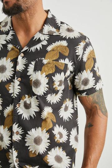 Moreno Short Sleeve Button Up with a Chest Patch Pocket in Sunflower Twirl Bark Colorway, White Sunflowers and Brown Leaves on Black  - Front View Featured on Model