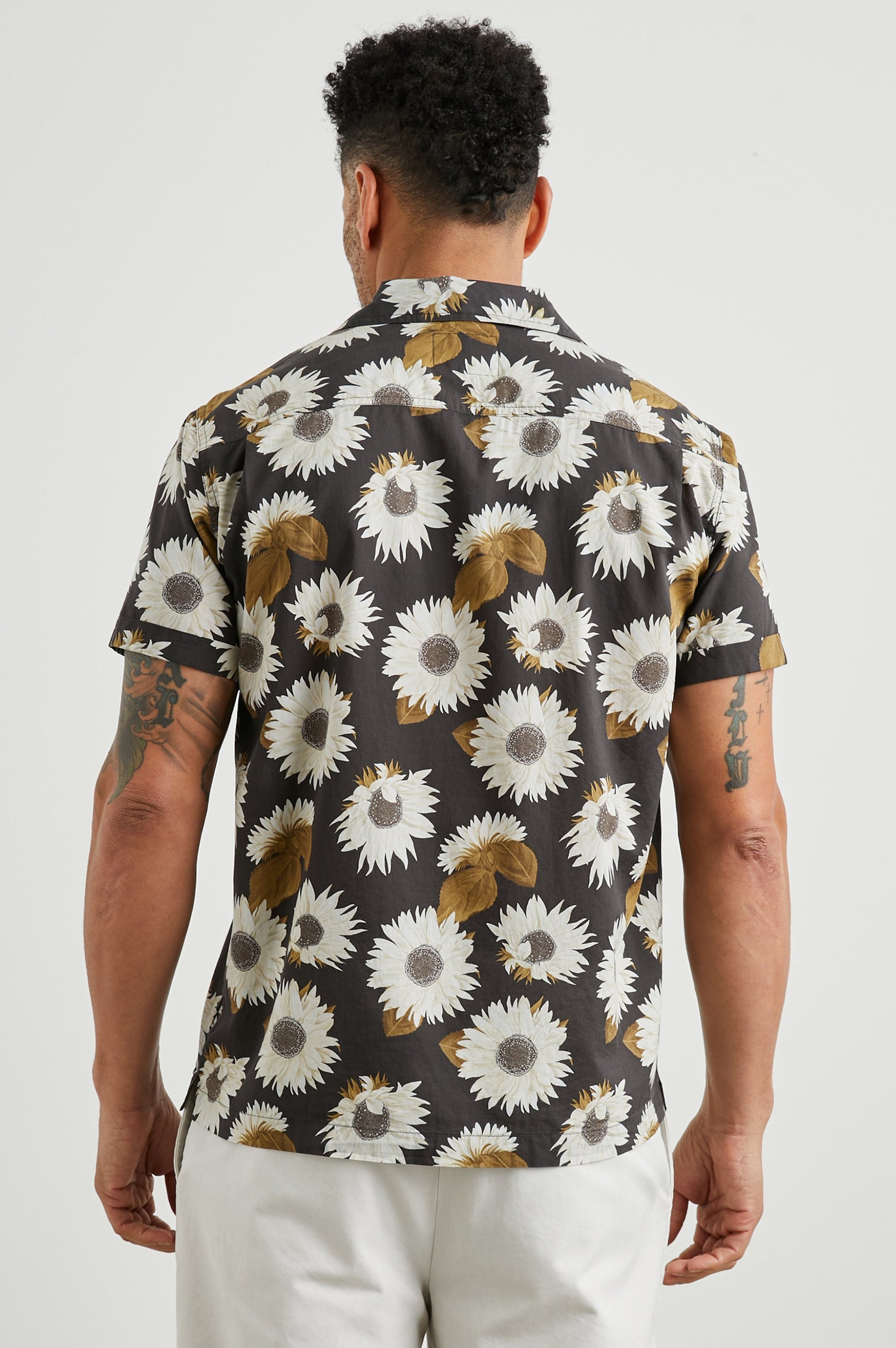 Moreno Short Sleeve Button Up with a Chest Patch Pocket in Sunflower Twirl Bark Colorway, White Sunflowers and Brown Leaves on Black  - Back View Featured on Model