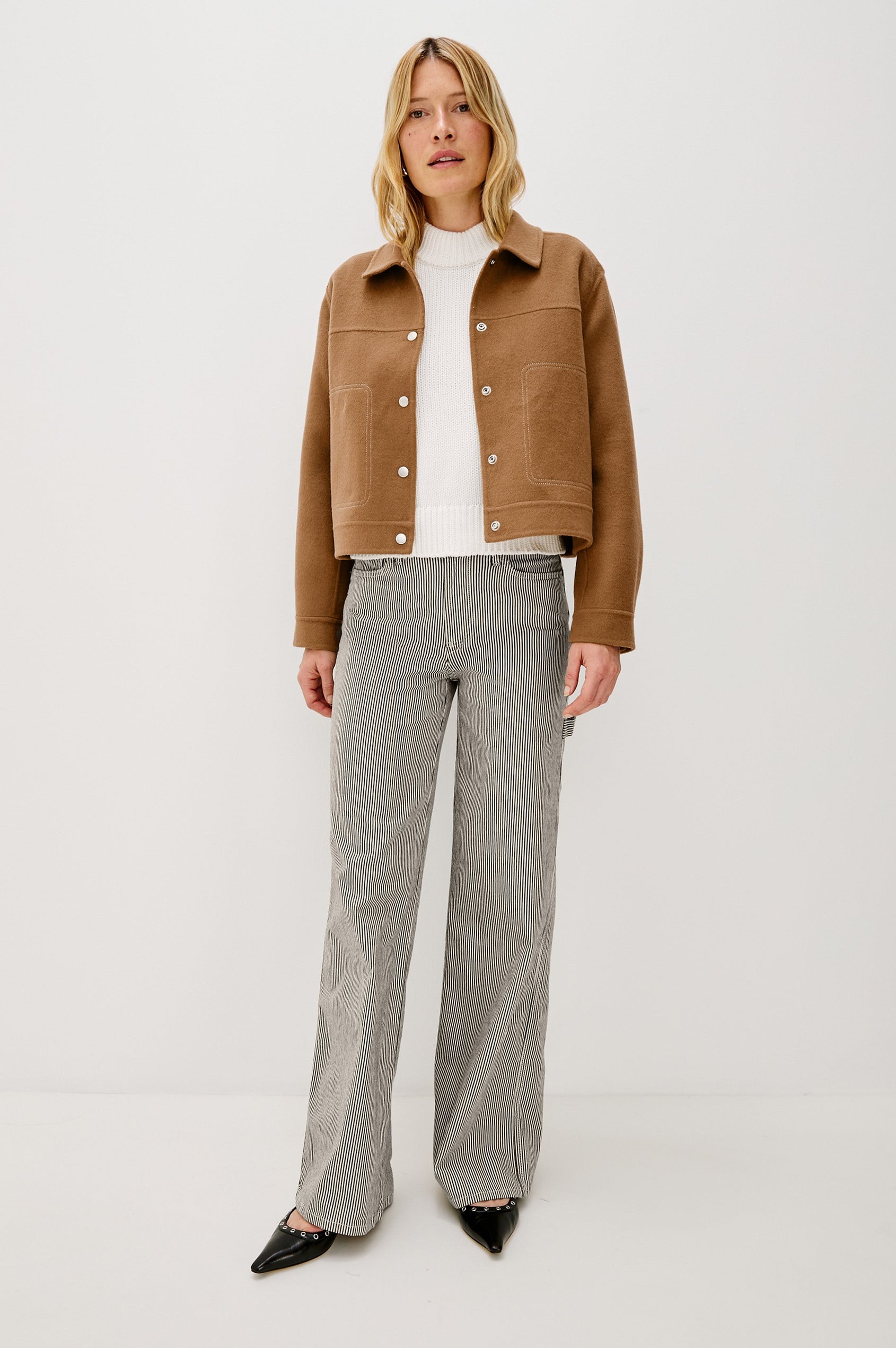 The Mountain jacket is cropped and collared with a snap front and side pockets in Camel colorway. Front full body view featured on model.