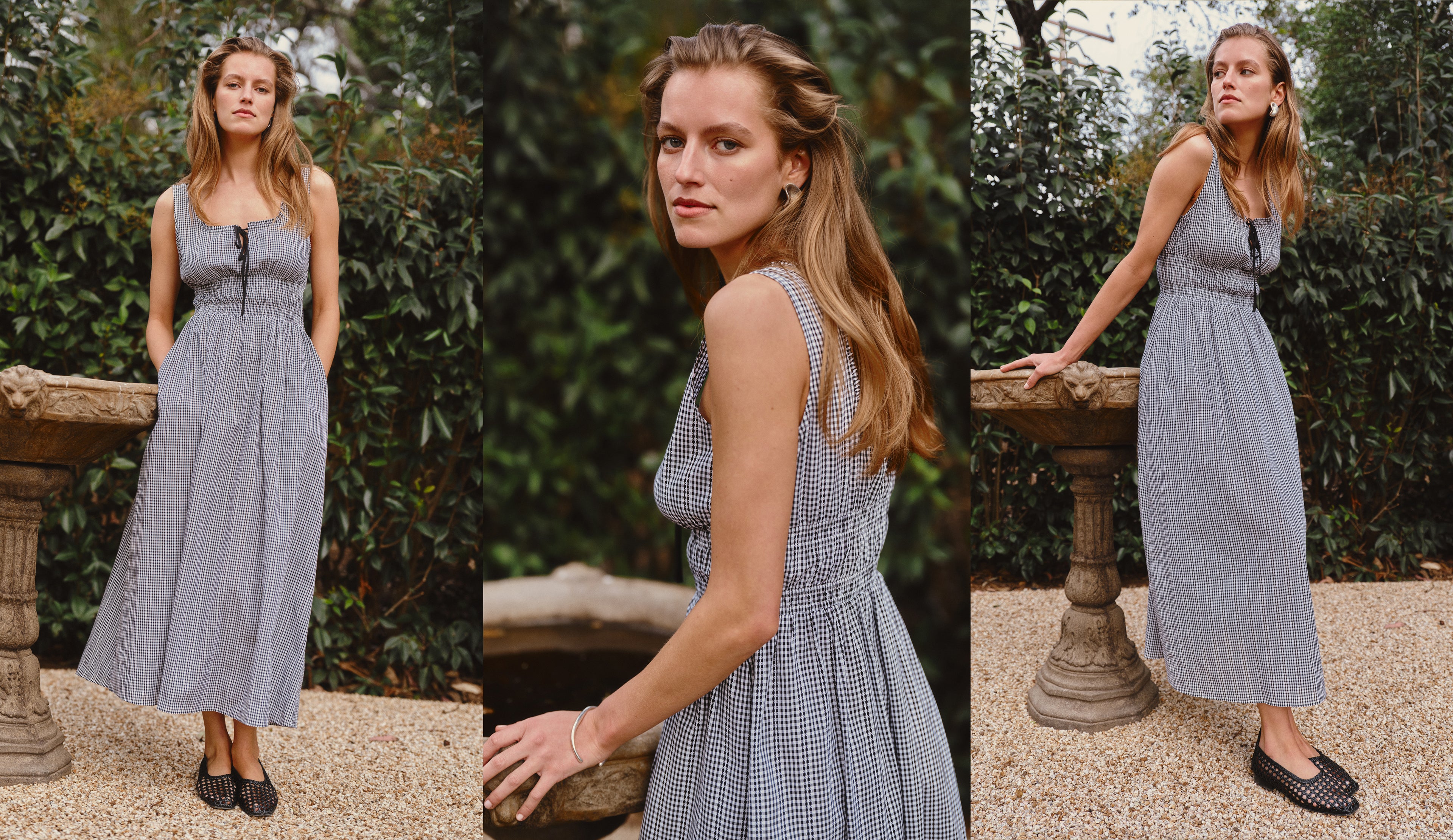 Woman in a gingham black and white dress surrounded by greenery 