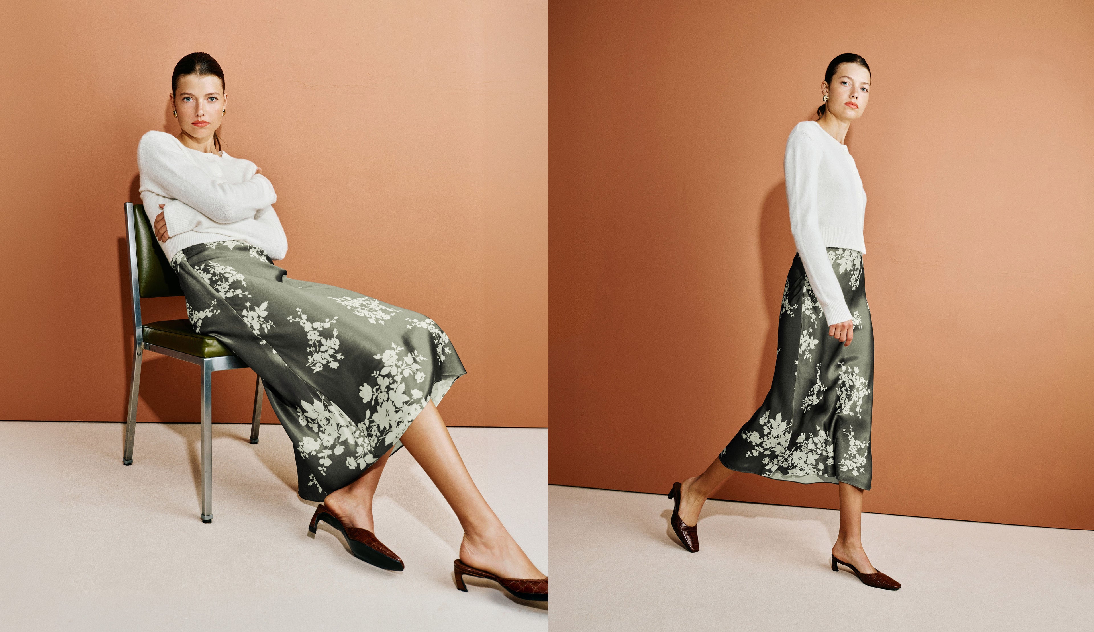 A model is shown in a split-screen fashion photo against a warm terracotta background. On the left, she sits on a dark chair wearing a white long-sleeve top and a dark green floral midi skirt with brown pointed-toe heels.