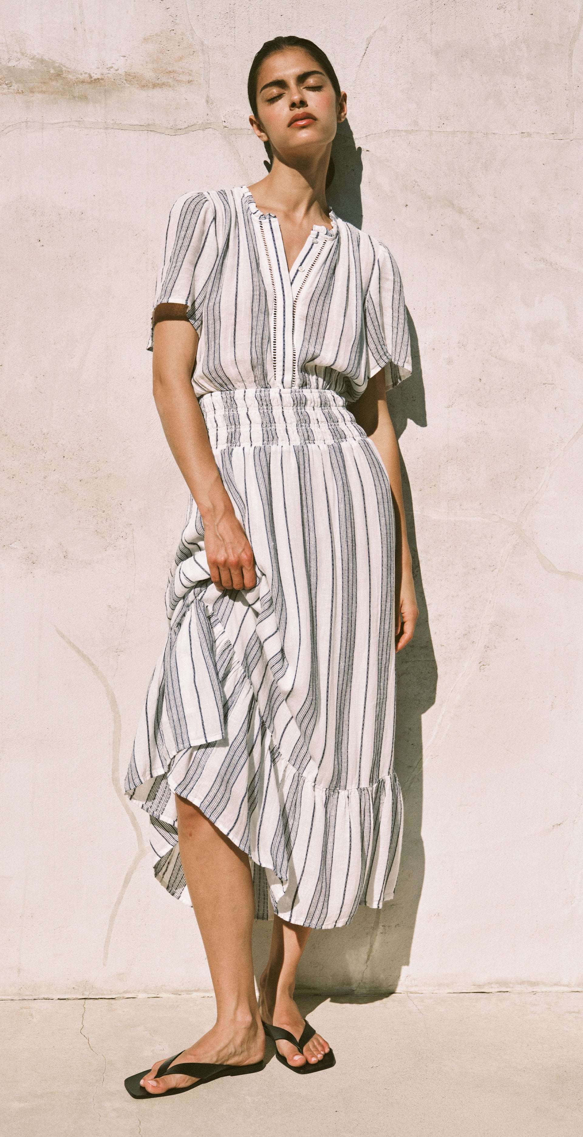 Woman wearing a striped dress against a neutral background
