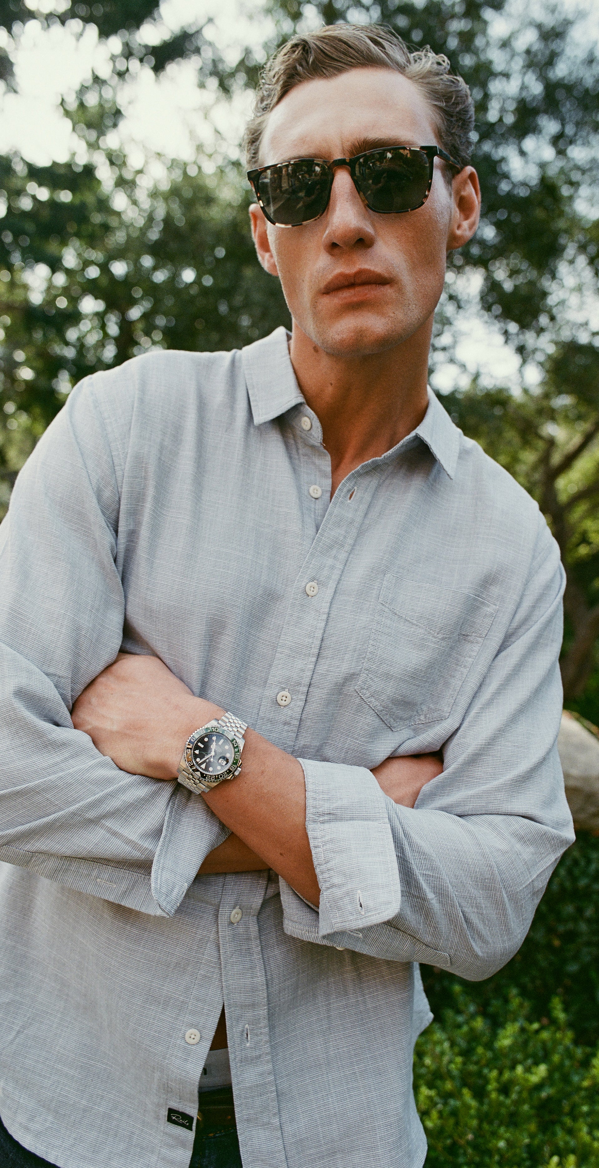 Man posing in a dress shirt with sunglasses