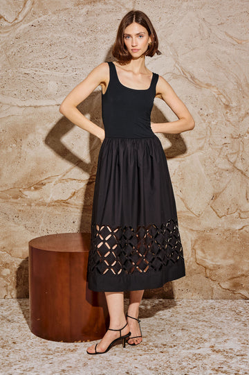 Nadya is a midi dress with a soft scoop neck bodice and a lightweight skirt in Black Colorway. The skirt features engineered cutouts from mid-thigh to hem and includes discreet on-seam pockets. Stylized full Body front view featured on model.