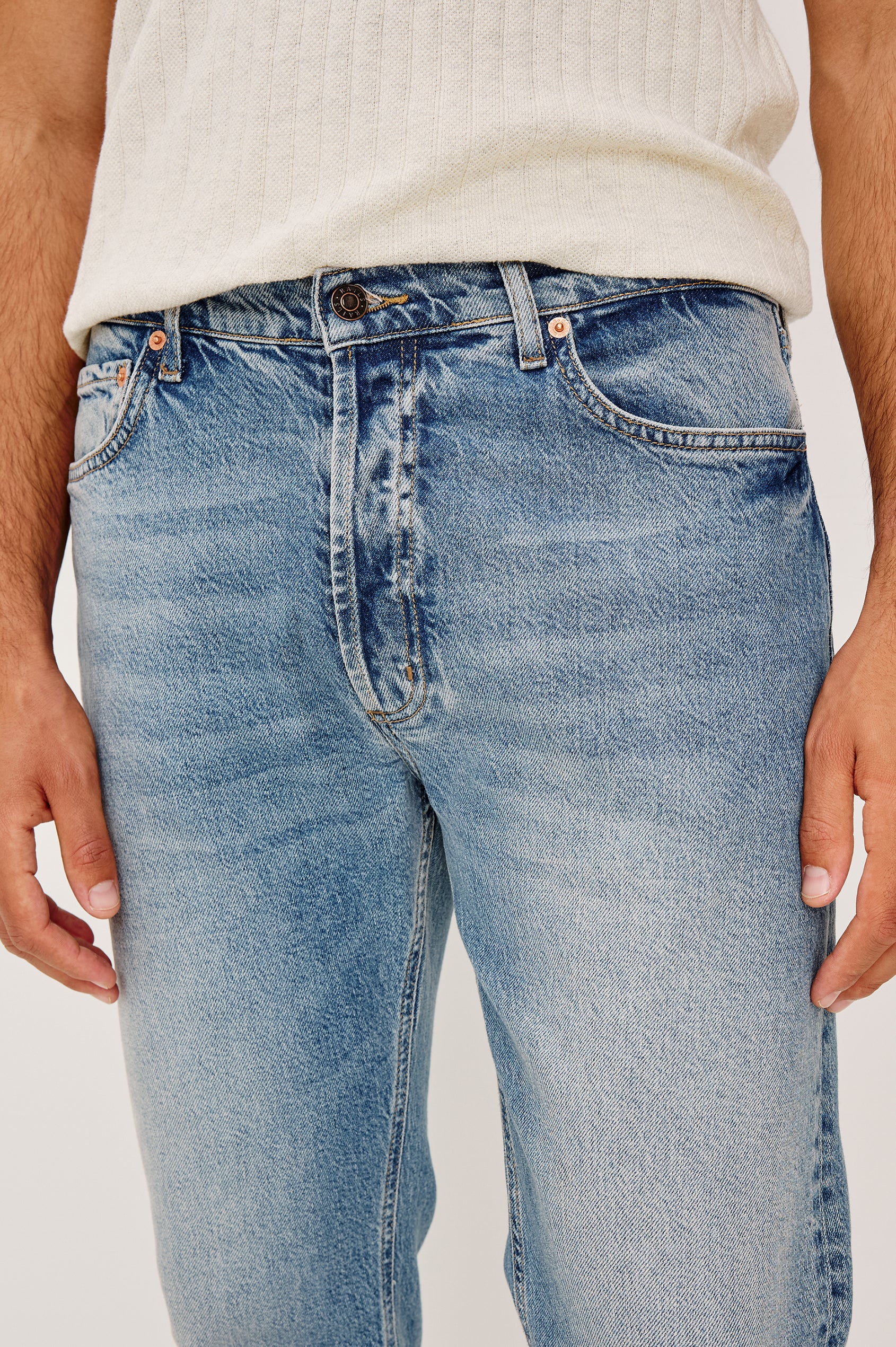 Nash is a straight leg 5-Pocket denim jean a zip fly and button closure as well as rivets in a Medium Vintage Wash. Front detail view featured on model.