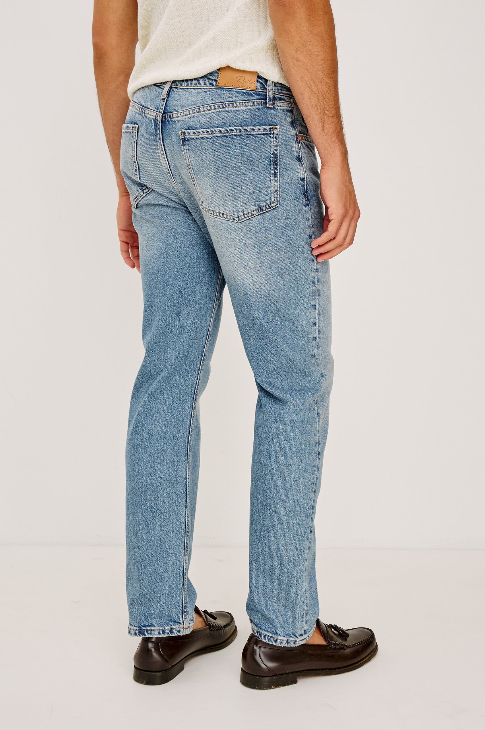 Nash is a straight leg 5-Pocket denim jean a zip fly and button closure as well as rivets in a Medium Vintage Wash. Back view featured on model.
