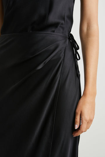Navi Sleeveless Midi Dress with a Halter Neckline with a Back Tie Keyhole, and a Wrap Skirt with a Side Tie Closure in Black Colorway - Front View Featured on Model  