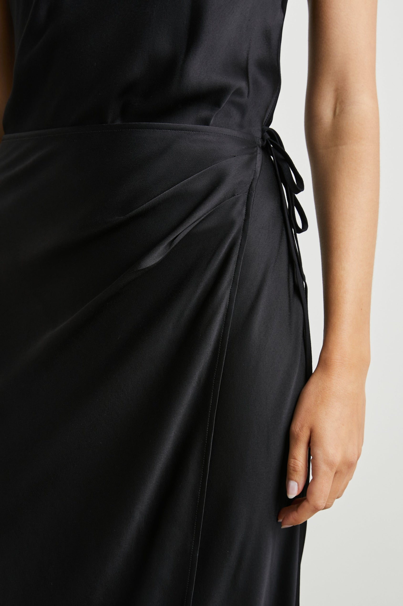Navi Sleeveless Midi Dress with a Halter Neckline with a Back Tie Keyhole, and a Wrap Skirt with a Side Tie Closure in Black Colorway - Front View Featured on Model  
