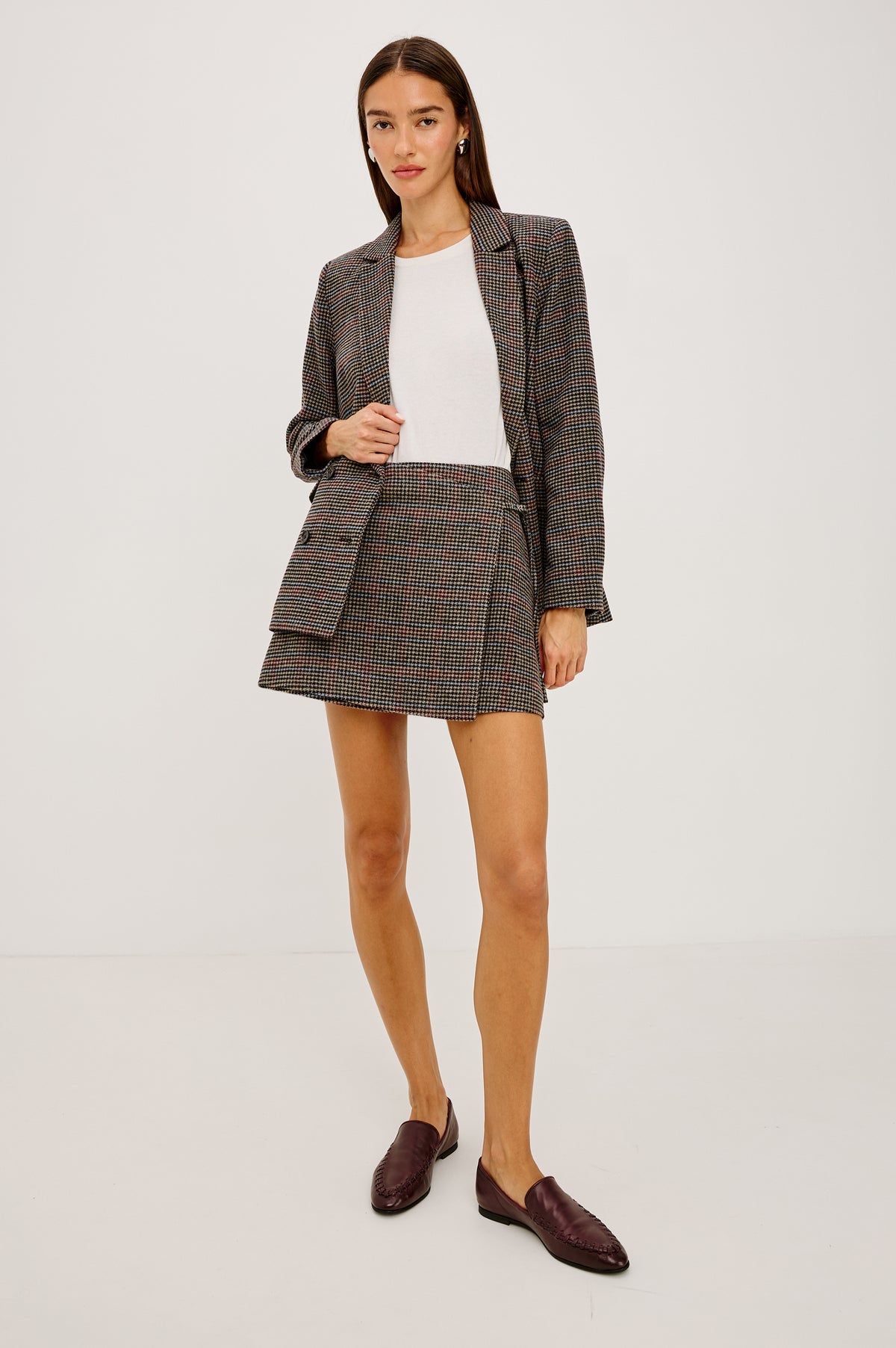 Nial Mini Skirt in Wool Blend With Wrap Front, Buckled Side Strap, Side Welt Pocket, Seam Zip Closure, and Fully Lined in Oxford Plum Colorway - Full Body Front View Featured on Model