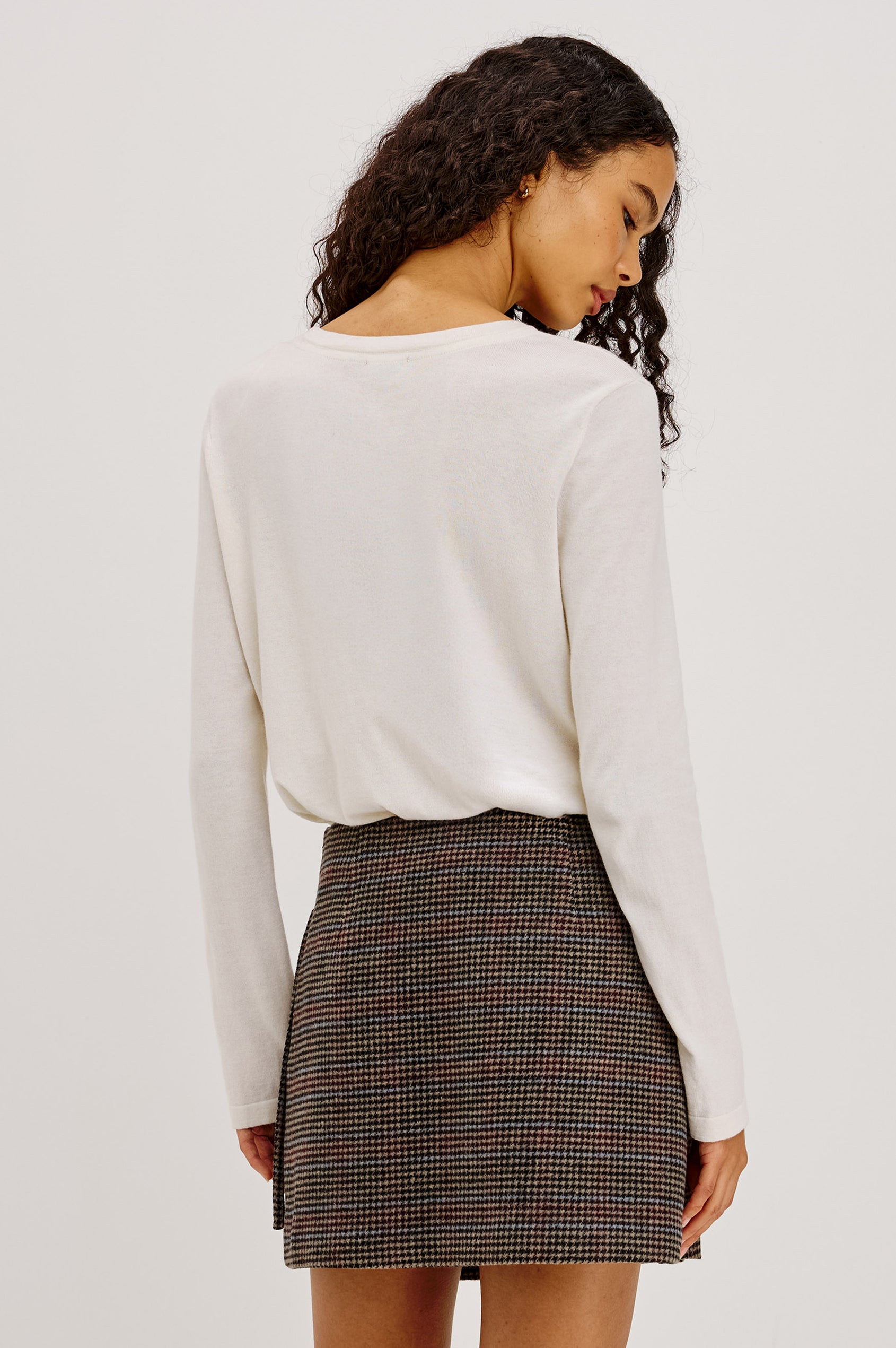 Nial Mini Skirt in Wool Blend With Wrap Front, Buckled Side Strap, Side Welt Pocket, Seam Zip Closure, and Fully Lined in Oxford Plum Colorway - Upper Body Back View Featured on Model