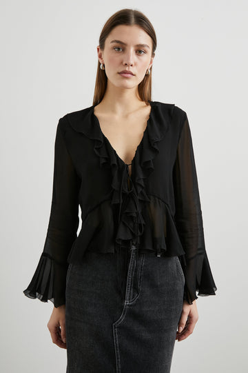 Nicoletta Long-Sleeve Semi-Sheer Top with Deep V Neck, Front Tie Closure, and Ruffled Trim in Black Colorway - Front View Featured on Model