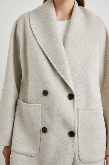 Nily Mid-Thigh Length, Double-Breasted Coat with Two Button Closure, Two Front Patch Pockets and a Shaw Collar in Oatmeal Colorway - Front View Featured on Model 