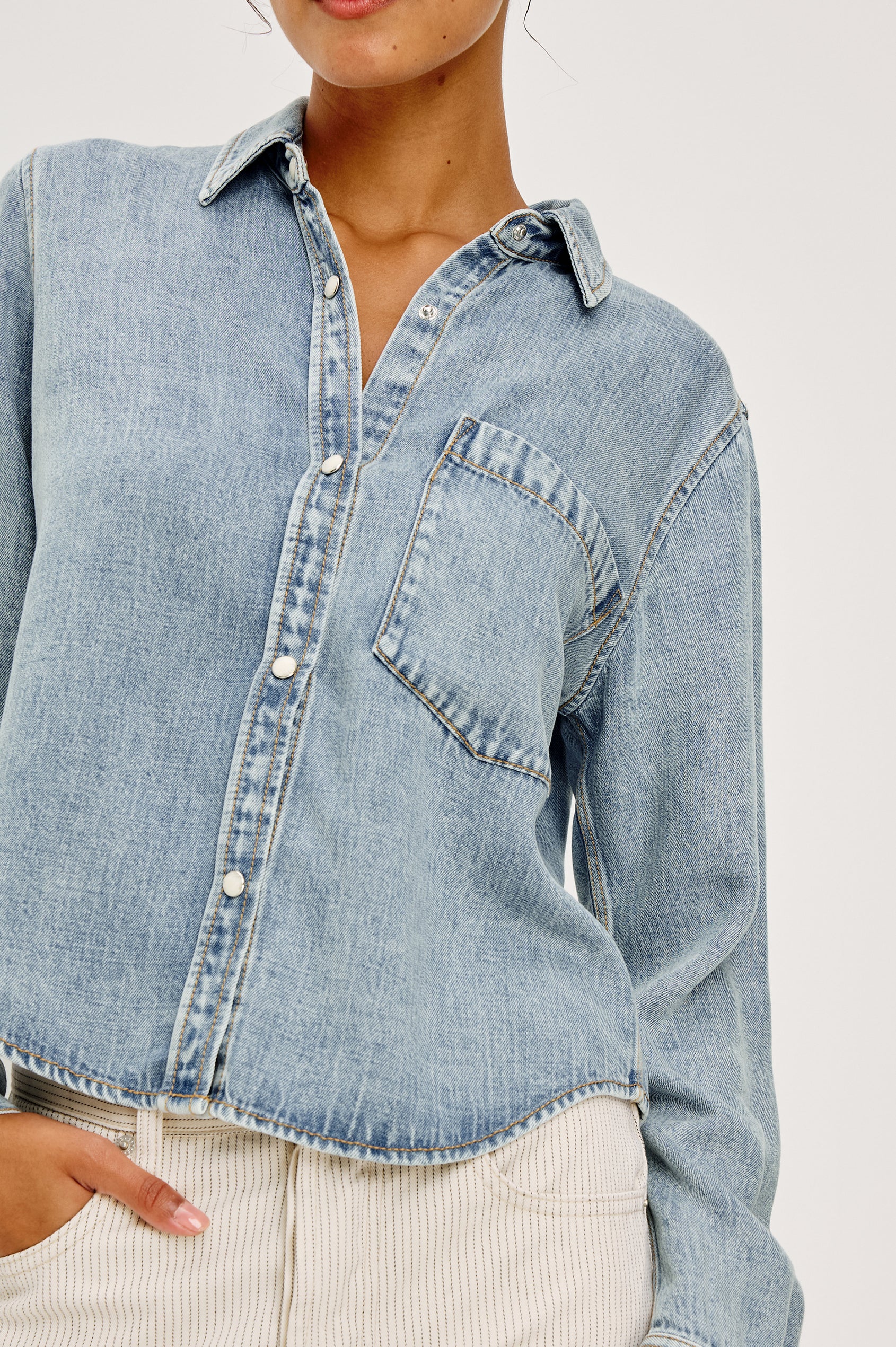 Noa Button-Up Shirt in Denim With Collar Front Buttons Single Chest Patch Pocket and Boxy Fit in Faded Indigo Colorway - Upper Body Close Up Front View Featured on Model