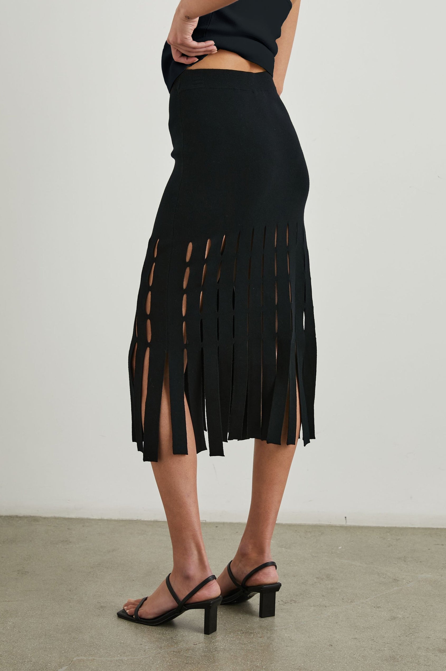 Nola Midi Skirt with Cutouts from the Mid-Thigh Down and Ending in Cut Panels in Black Colorway - Back View Featured on Model 