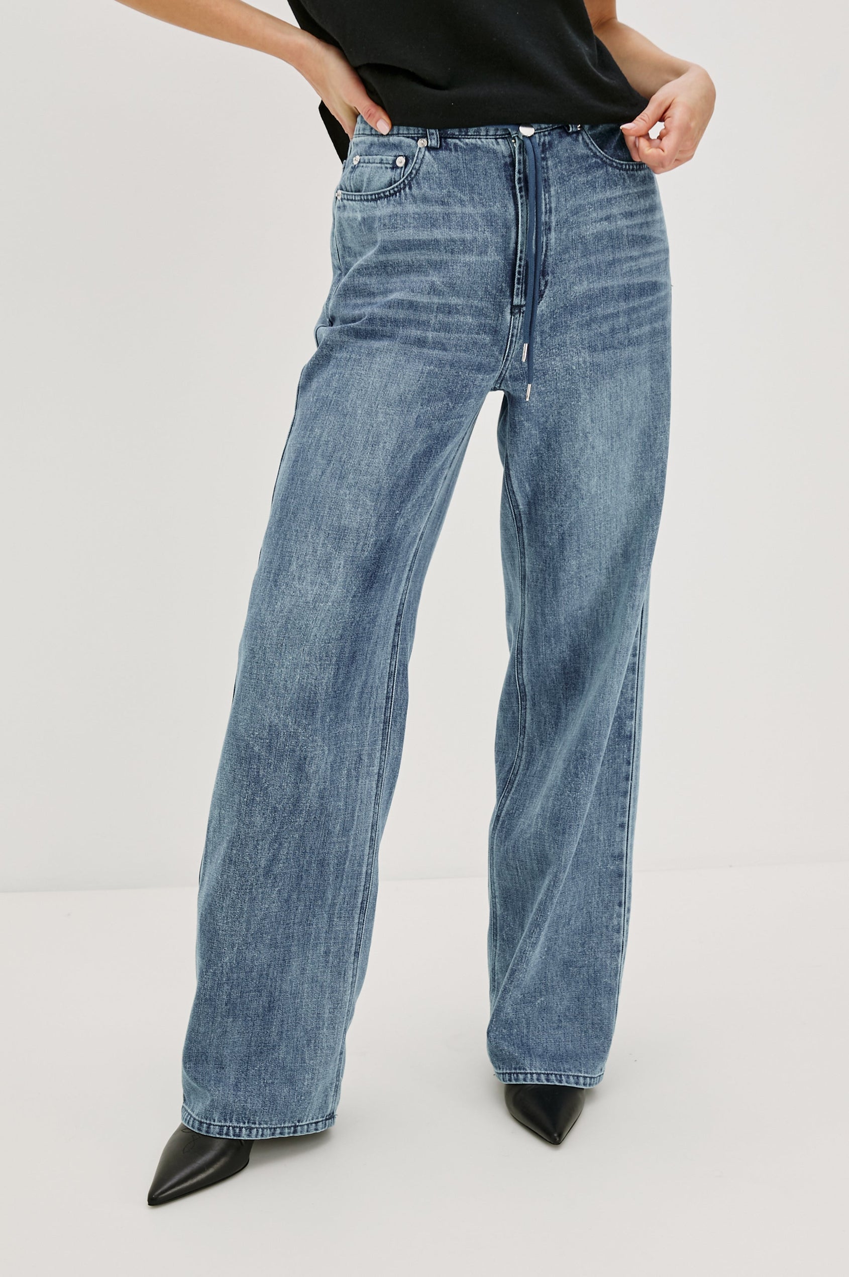 Normandie Lightweight 5-Pocket Denim Wide Leg Pant with front zipper button fly and a drawstring tie at waist in Antique Blue Colorway. Front View Featured on Model.