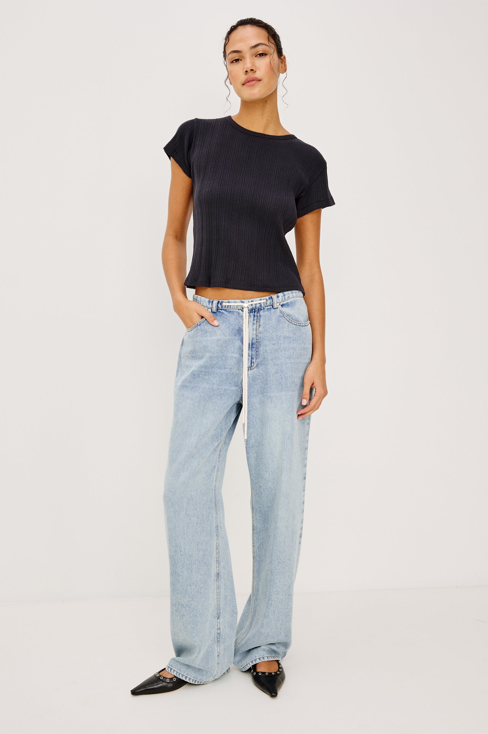 Normandie Pant in Cotton Lyocell Denim With Low-Slung Fit, Adjustable Toggle Drawstring Waist Ties, 5-Pockets, and Loose Fit in Sun Kissed Blue Colorway - Lower Body Front View Featured on Model