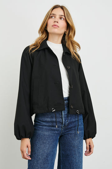 North Cropped Jacket with Button Closure, Puff Sleeves, Oversize Collar, a Toggle Hem, Two Front Pockets and a Horizontal Back Vent in Black Twill Colorway - Front View Featured on Model