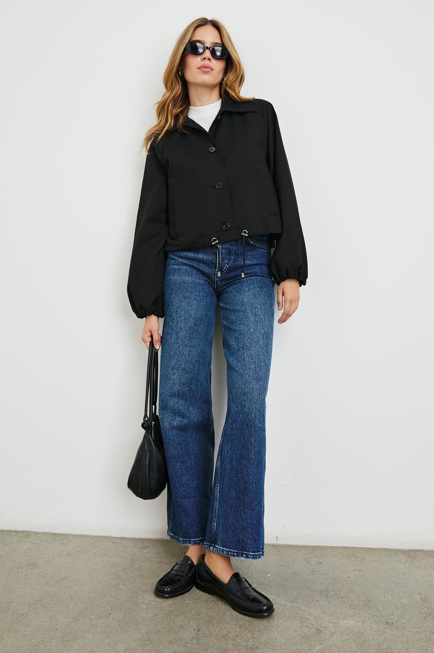 North Cropped Jacket with Button Closure, Puff Sleeves, Oversize Collar, a Toggle Hem, Two Front Pockets and a Horizontal Back Vent in Black Twill Colorway - Front Full Body View Featured on Model