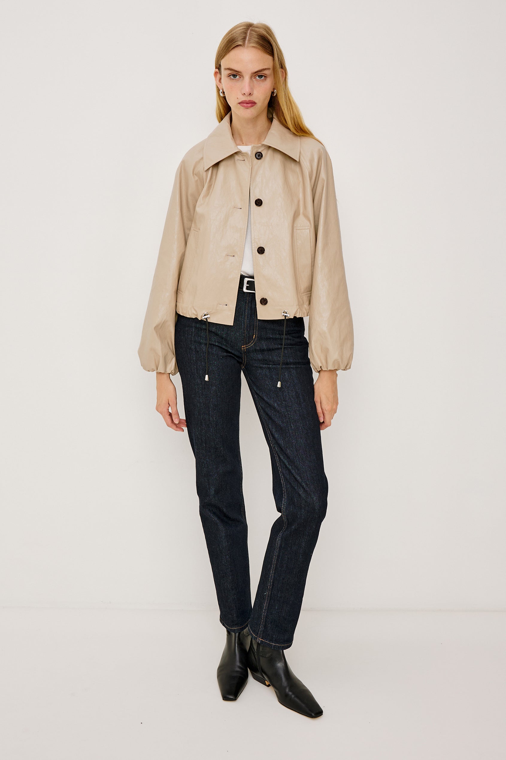 North Cropped Jacket in Faux Leather With Loose Boxy Fit, Oversized Collar, Front Buttons, Side Pockets, Drawstring Hem, Long Lantern Sleeves With Elastic Cuffs in Dune Colorway - Full Body Front View Featured on Model