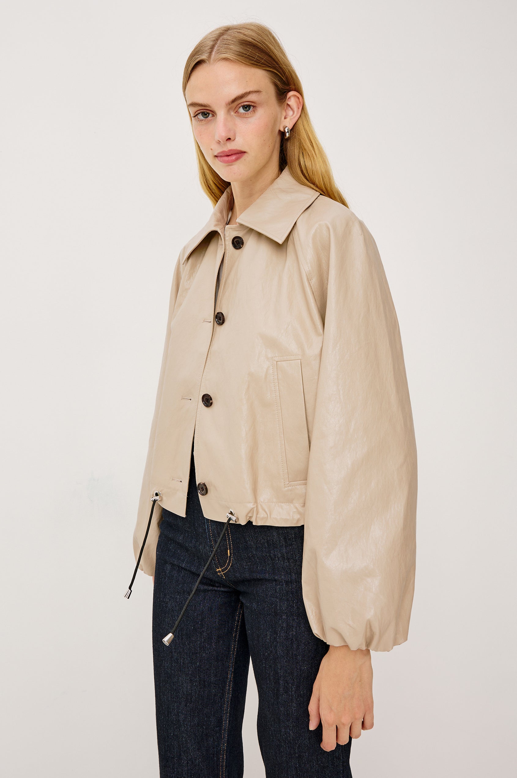North Cropped Jacket in Faux Leather With Loose Boxy Fit, Oversized Collar, Front Buttons, Side Pockets, Drawstring Hem, Long Lantern Sleeves With Elastic Cuffs in Dune Colorway - Upper Body Front View Featured on Model