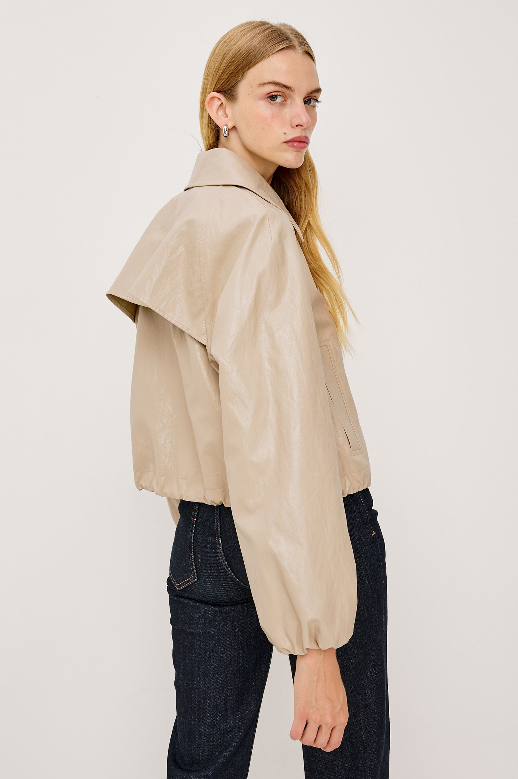 North Cropped Jacket in Faux Leather With Loose Boxy Fit, Oversized Collar, Front Buttons, Side Pockets, Drawstring Hem, Long Lantern Sleeves With Elastic Cuffs in Dune Colorway - Upper Body Back View Featured on Model