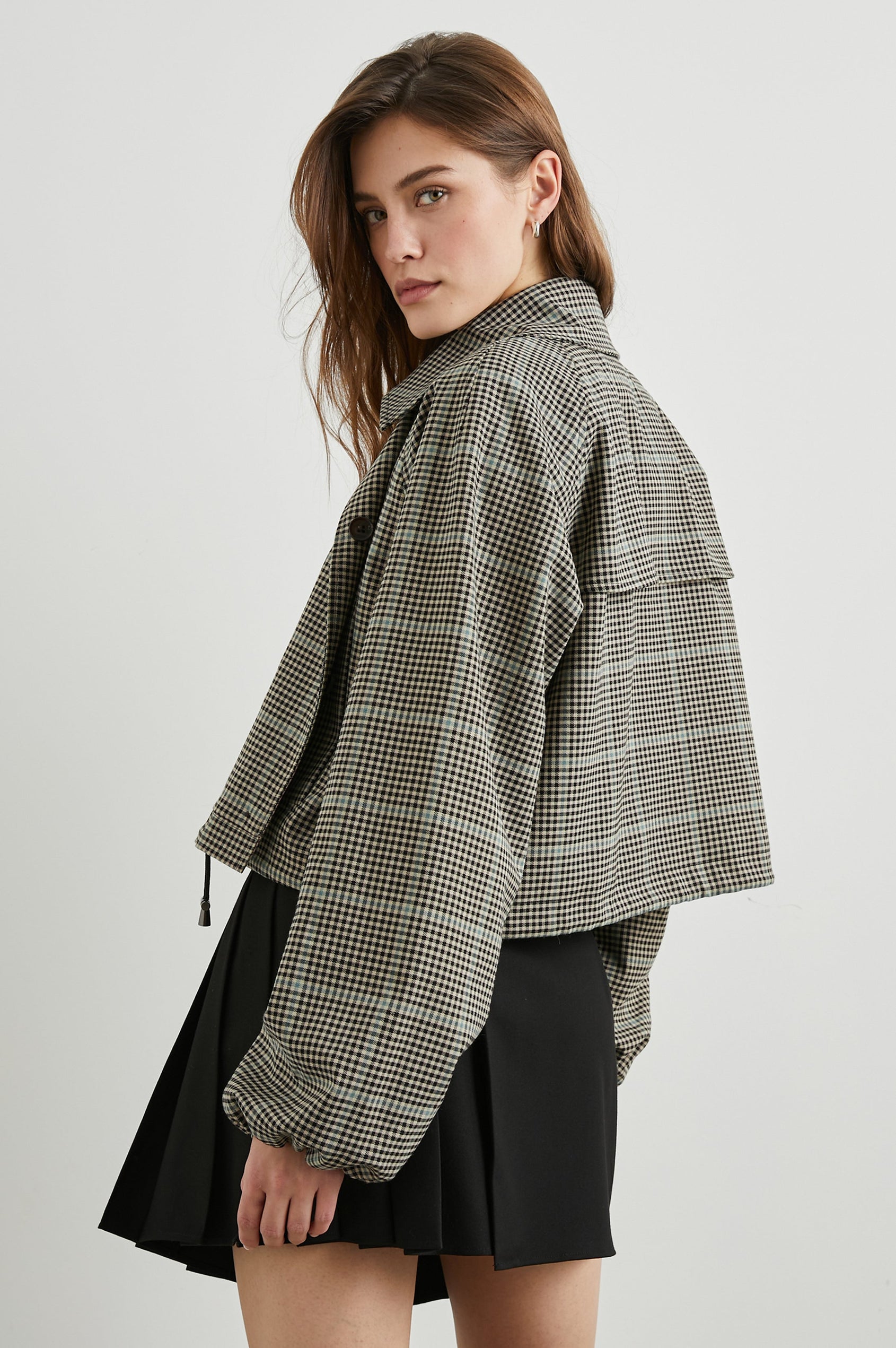 North Cropped Jacket with Button Closure, Puff Sleeves, Oversize Collar, a Toggle Hem, Two Front Pockets and a Horizontal Back Vent in Teal Multi Check Colorway, a Black, Tan and Teal Plaid - Back View Featured on Model