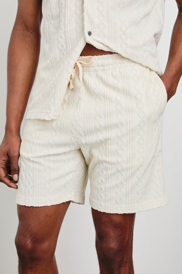 Nova Shorts with a Drawstring Waist, a Raised Jacquard Pattern, Two Front Pockets and a Back Patch Pocket in Ecru Colorway - Front View Featured on Model