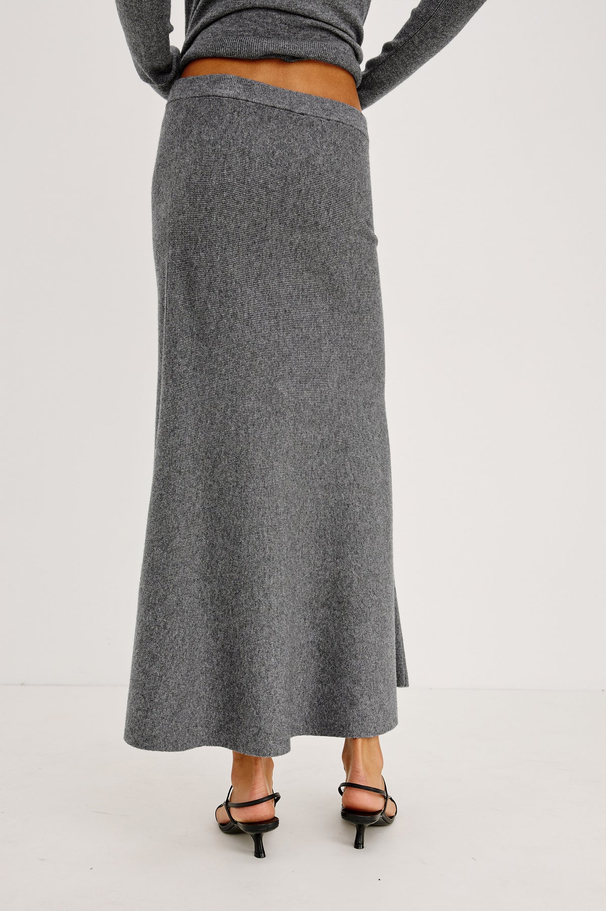 Odita Maxi Skirt in Soft Ribbed Wool Blend Knit With Elastic Waist, and A-Line Silhoeutte in Heather Charcoal Colorway - Crop Back View Featured on Model.