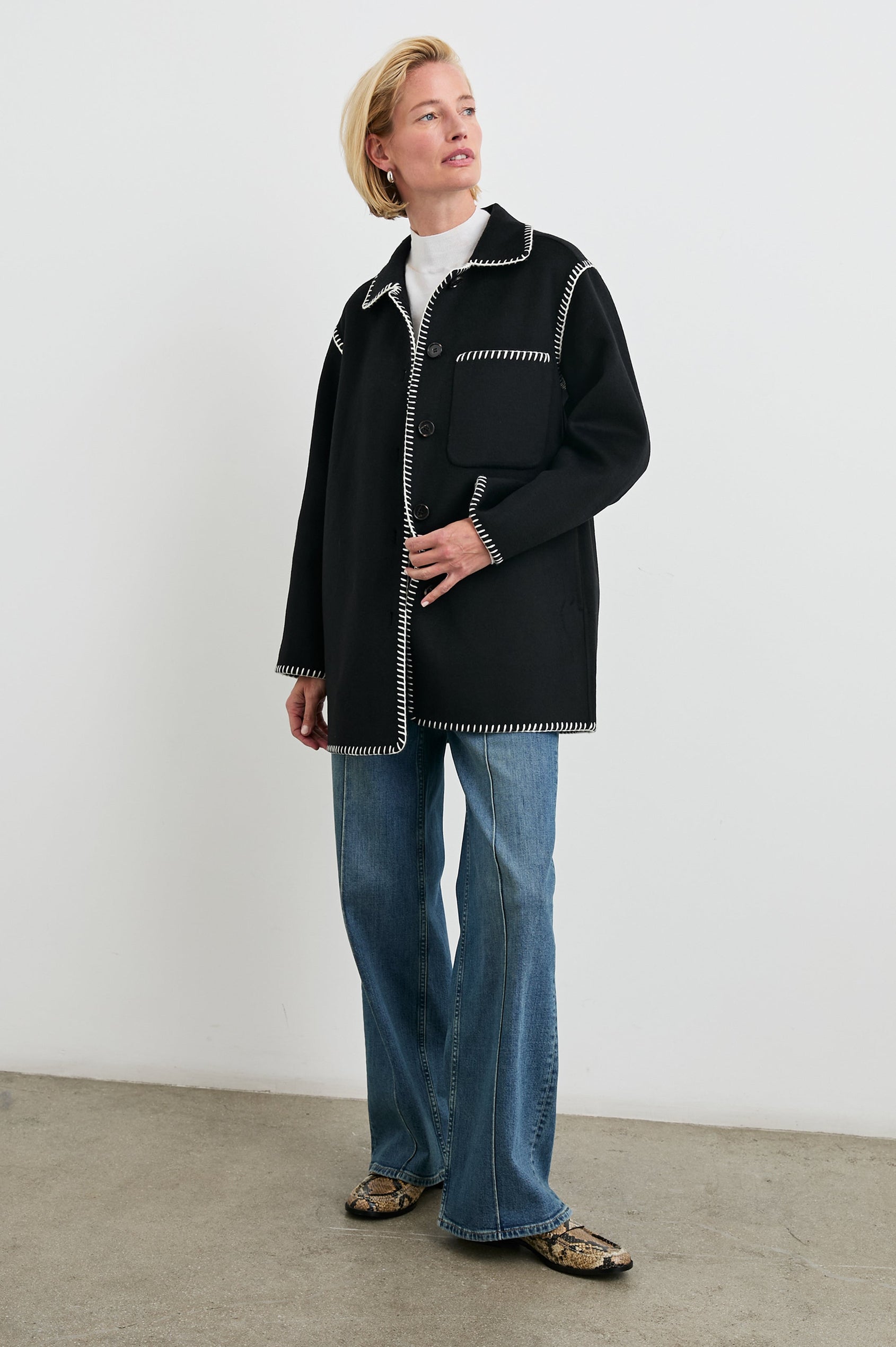 Odyssey Jacket with Four Button Closure and a Chest Patch Pocket in Black Colorway, with white contrast stitching - Front Full Body View Featured on Model