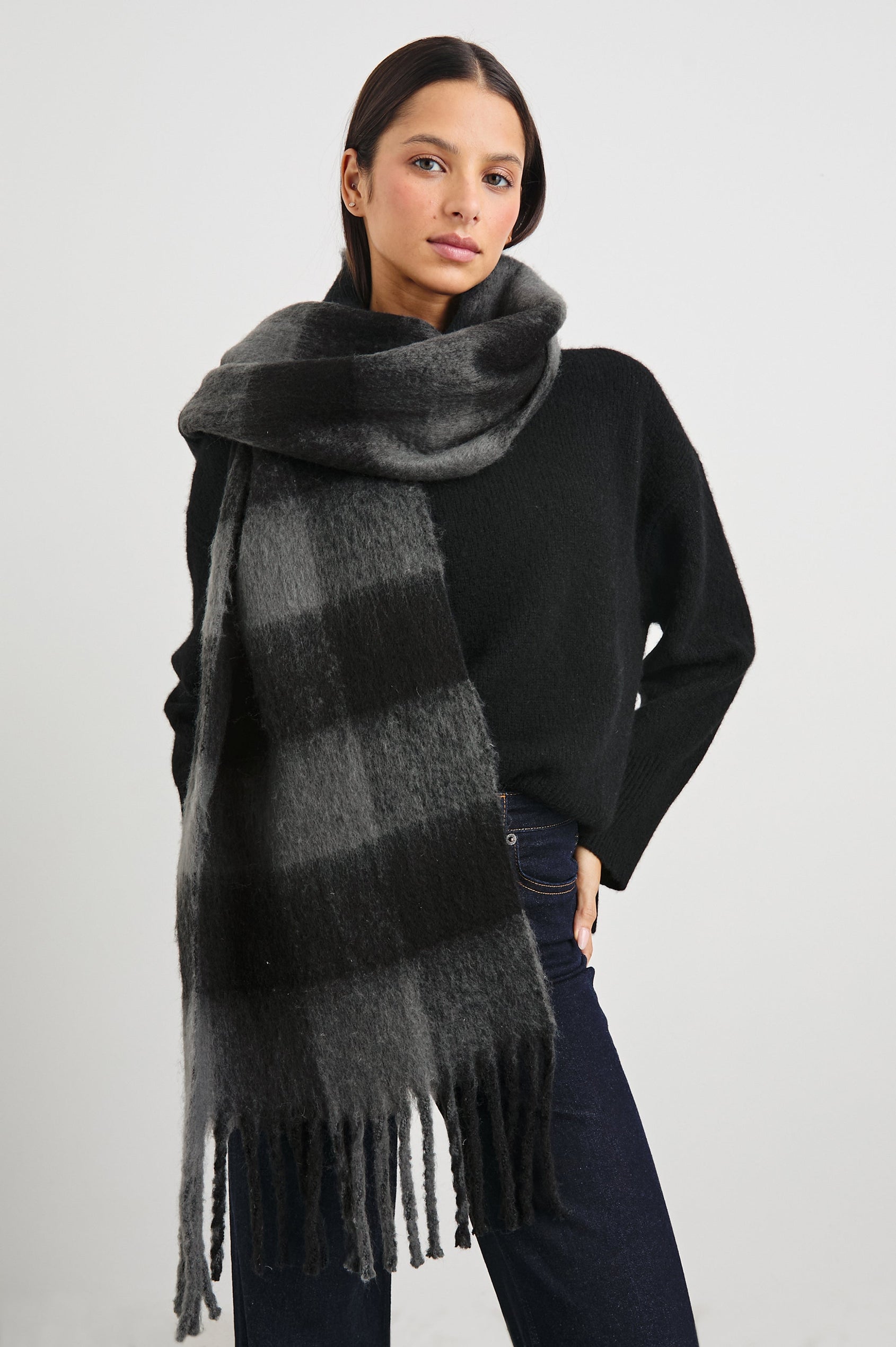 Oslo Scarf with Twisted Tassels and a Checkered Pattern in Charcoal Black Colorway - Front View Featured on Model