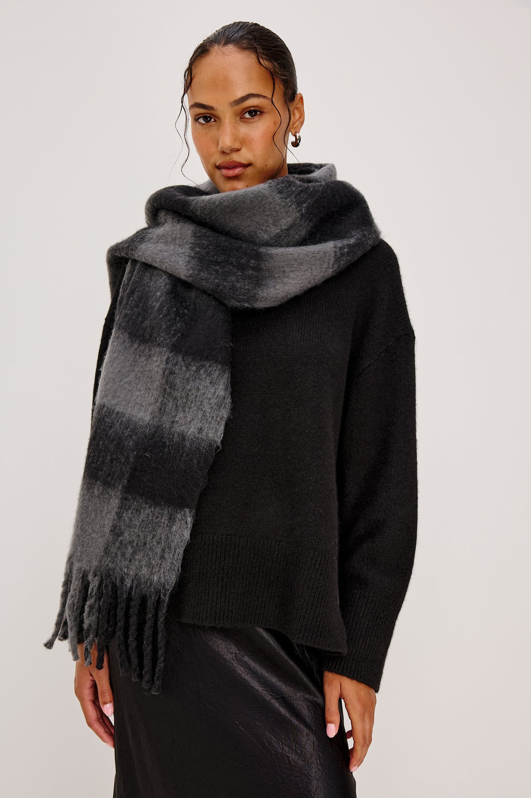 Oslo Scarf with Twisted Tassels and a Checkered Pattern in Charcoal Black Colorway - Front View Featured on Model