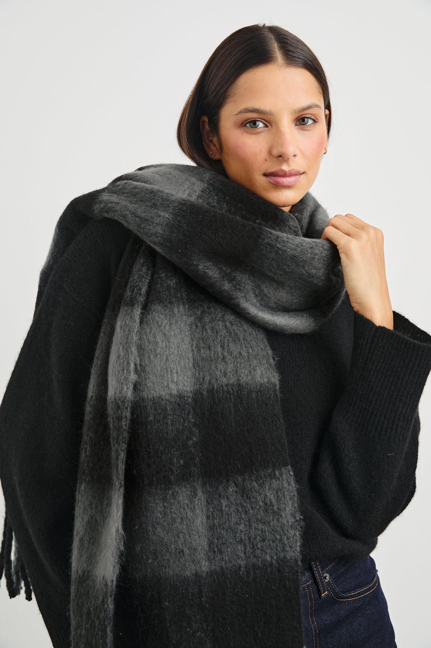 Oslo Scarf with Twisted Tassels and a Checkered Pattern in Charcoal Black Colorway - Front View Featured on Model