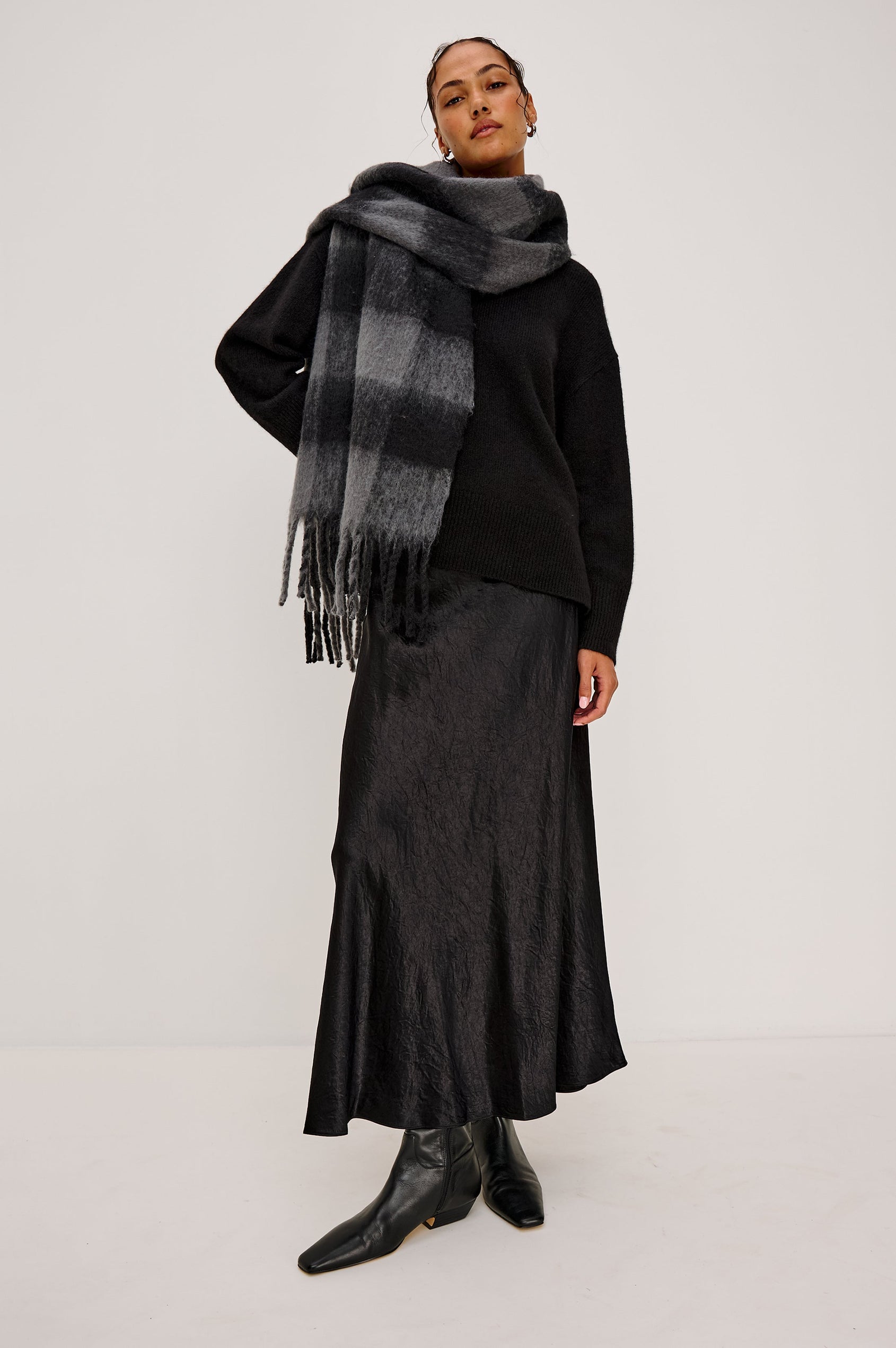 Oslo Scarf with Twisted Tassels and a Checkered Pattern in Charcoal Black Colorway - Front Full Body View Featured on Model