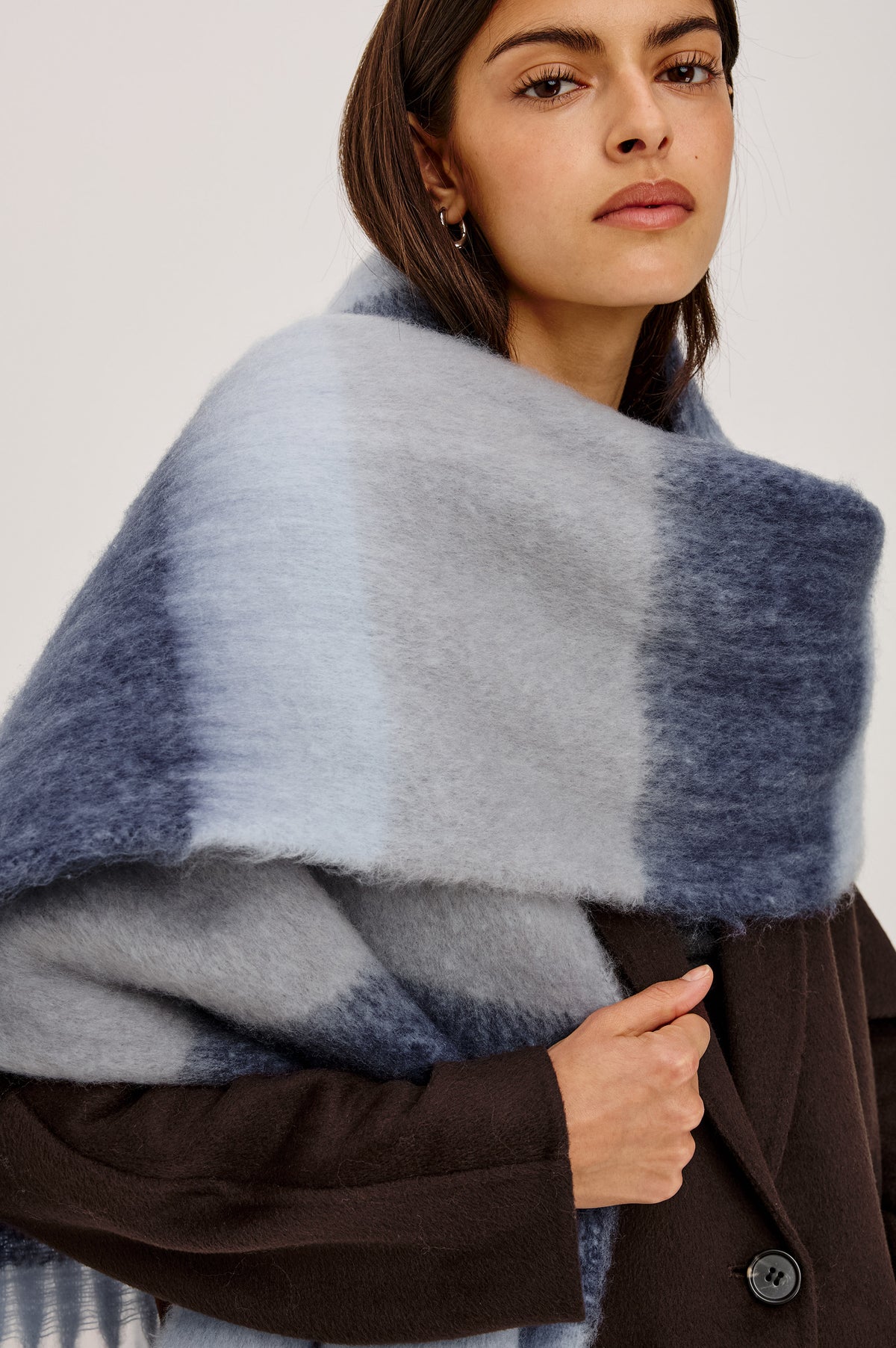 Oslo Scarf in Brushed Polyester Knit With Oversized Shape and Fringe Trim in Sky Indigo Stripe Colorway - Upper Body Front Detail View Featured on Model.