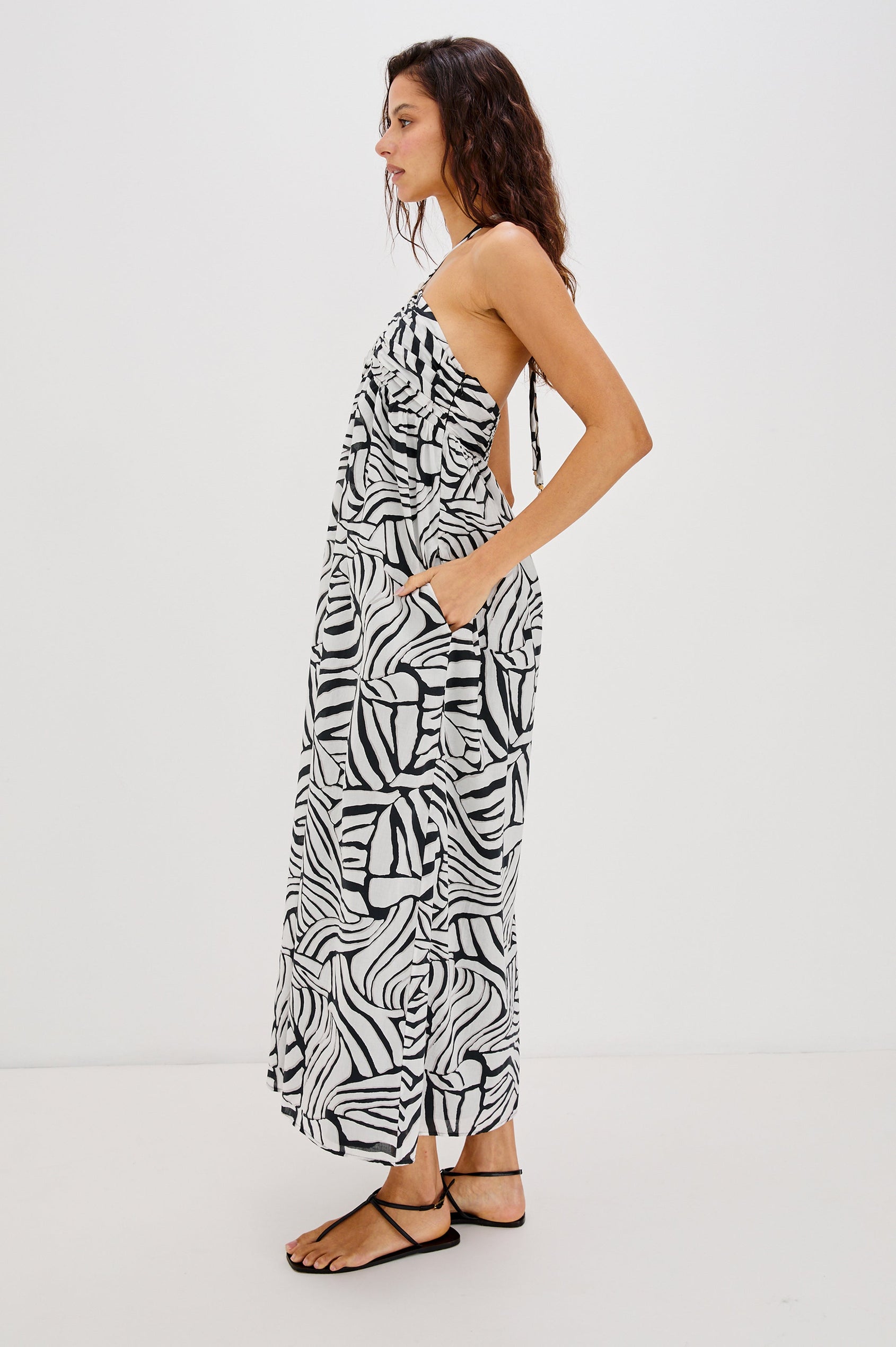 Palazzo Halter Midi Length Dress with Tie Neck and Sea Shell Lattice Detail at Center Front in White and Black Abstract Playa Blanco Colorway. Full Body Side View Shown on Model.