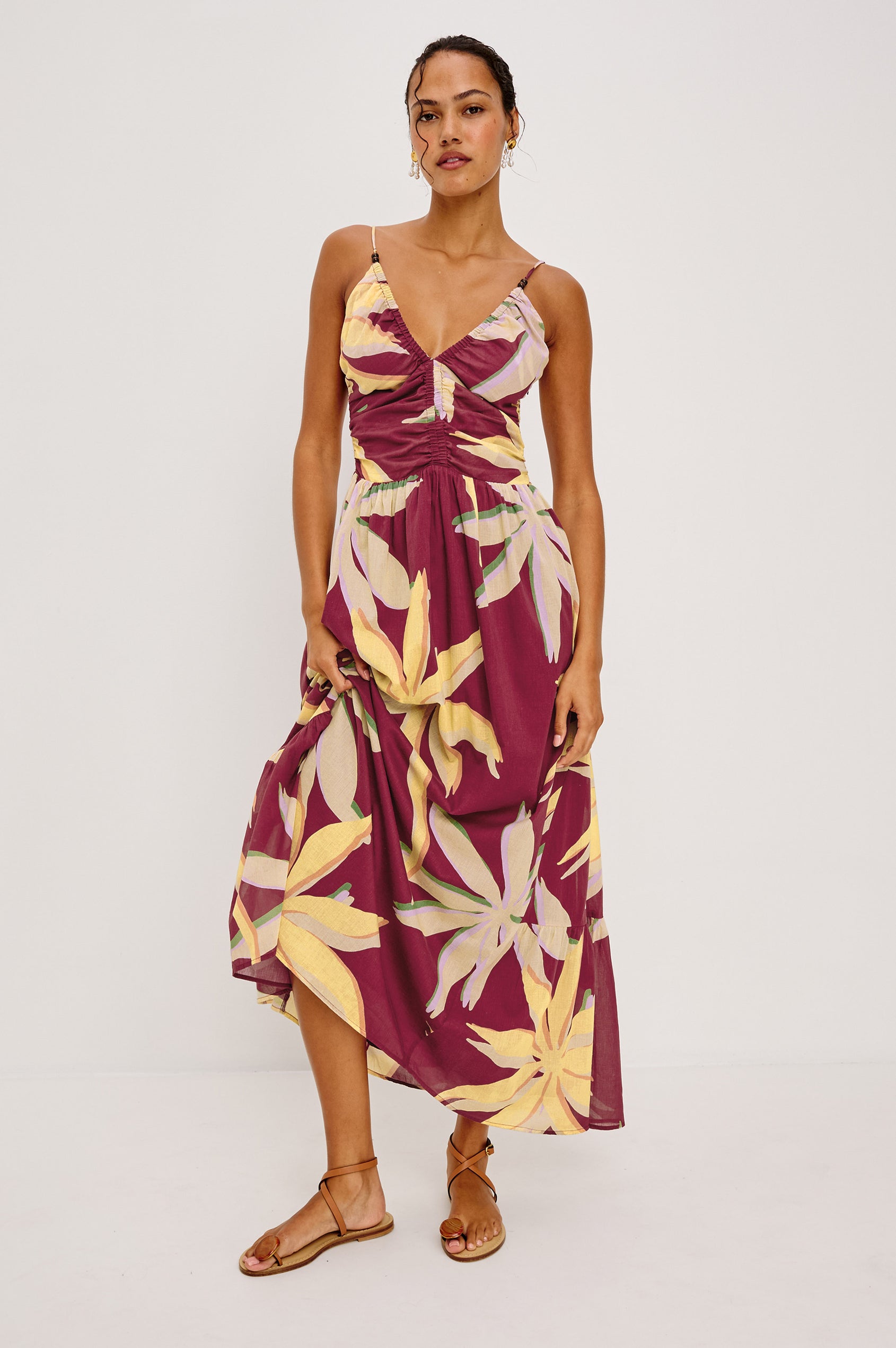 Palm Maxi Dress in Beach Cotton WIth Fitted Shirred Bodice V-Neckline Adjustable Shoulder Straps With Wooden Bead Detailing and Tiered Skirt in Red Palma Colorway - Full Body Front View Featured on Model