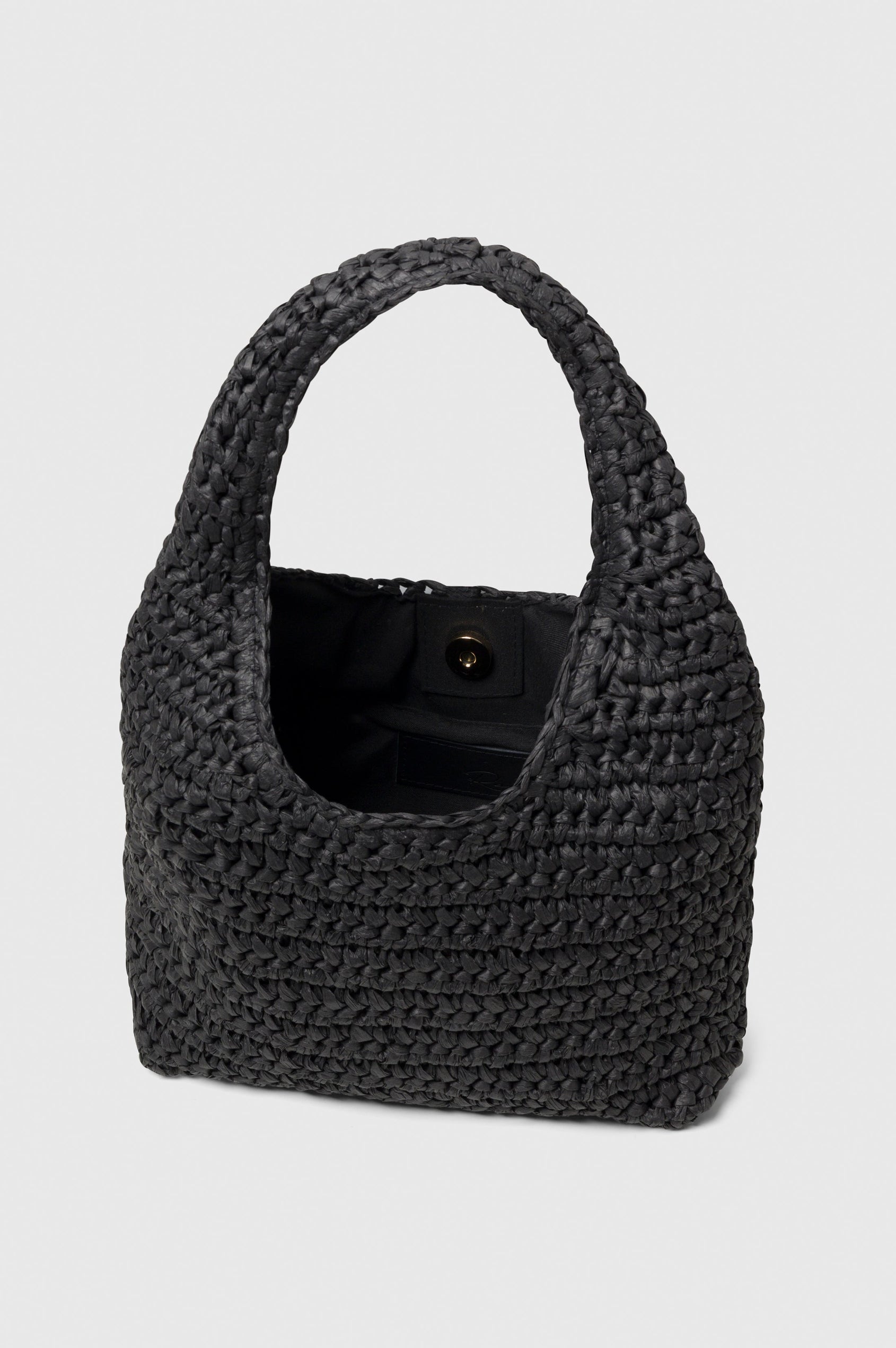 Palma rattan woven shoulder bag in Black - view of open bag with interior pocket and button closure