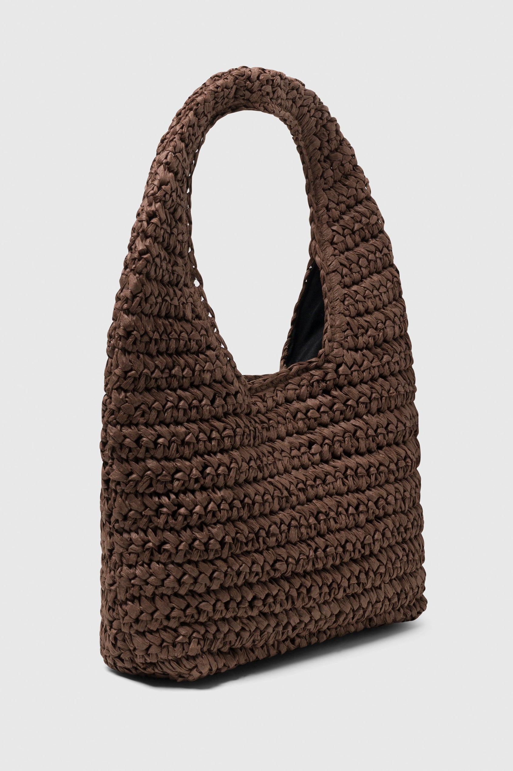 Palma Rattan Shoulder Bag with a Snap Closure and an Interior Pocket in Dark Brown Colorway. Side view of Bag.