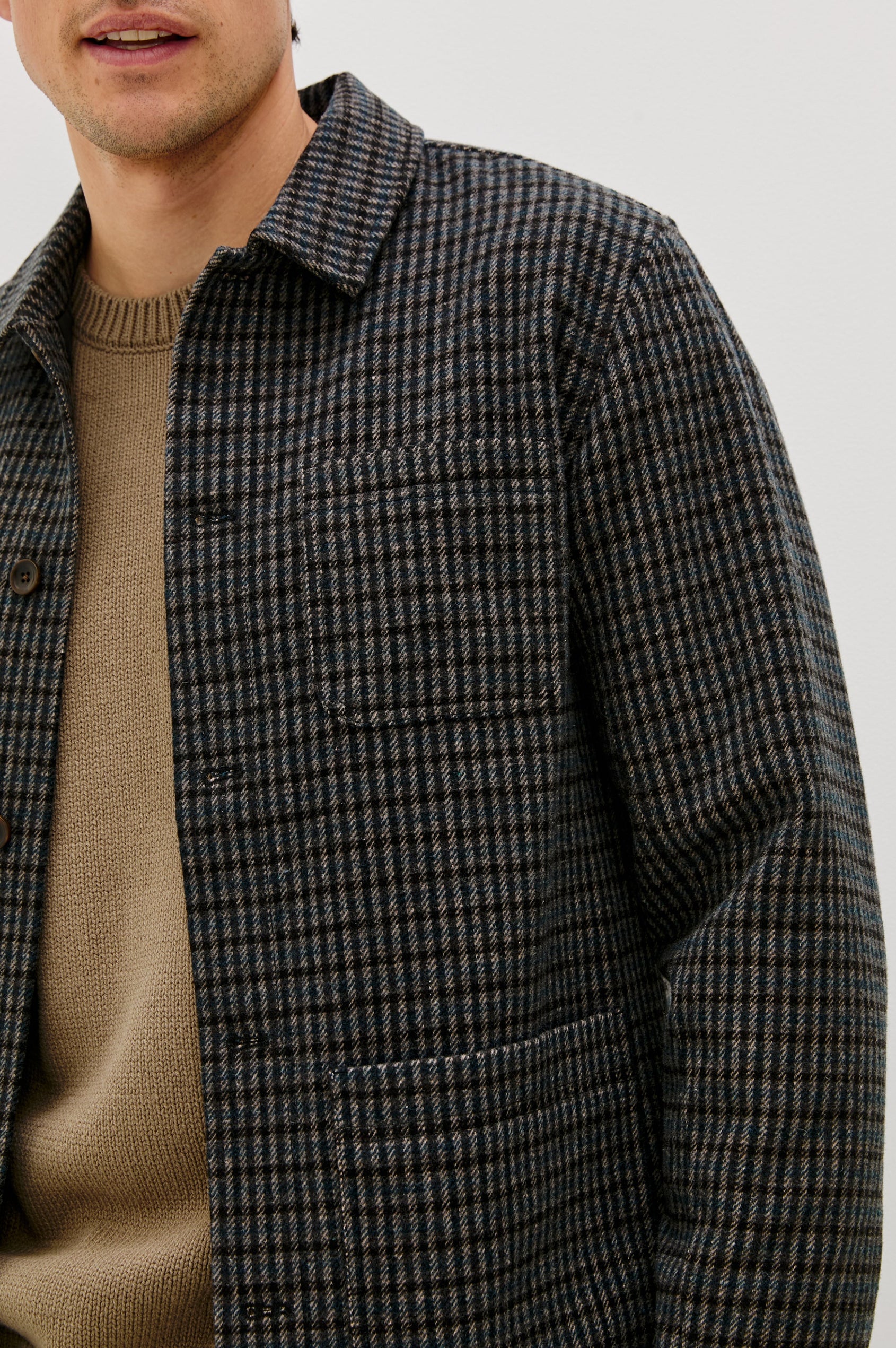 The Pascal is a collared button front jacket with front patch pockets and a chest pocket in Grey Check Plaid colorway. Front detail view featured on model.