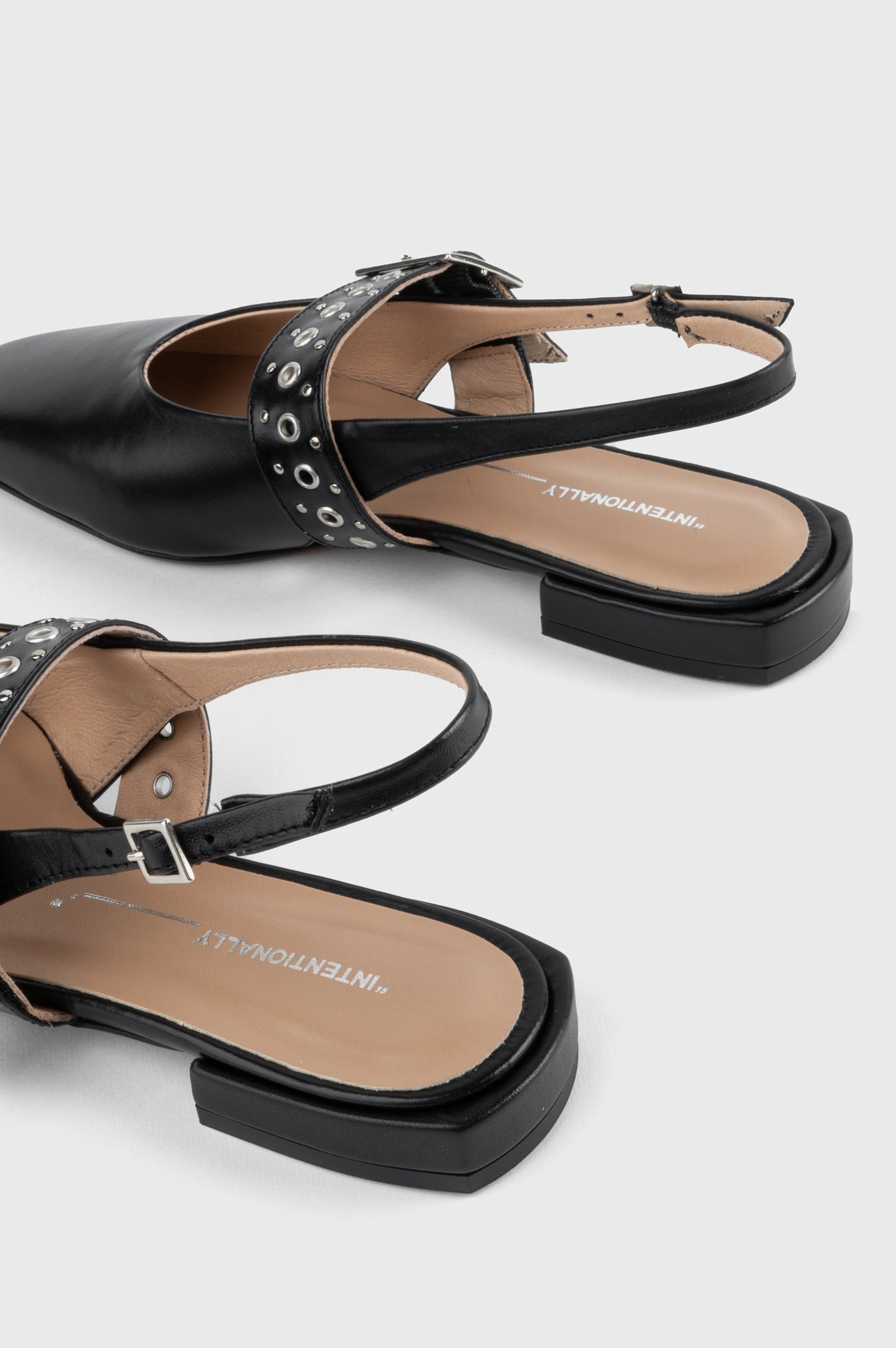 Intentionally Blank Pearl Ballet Flat with an Adjustable Slingback Strap, a Studded Upper Buckle Strap, a Small Heel and a Square Toe in Black Colorway - overhead view of back half of shoe