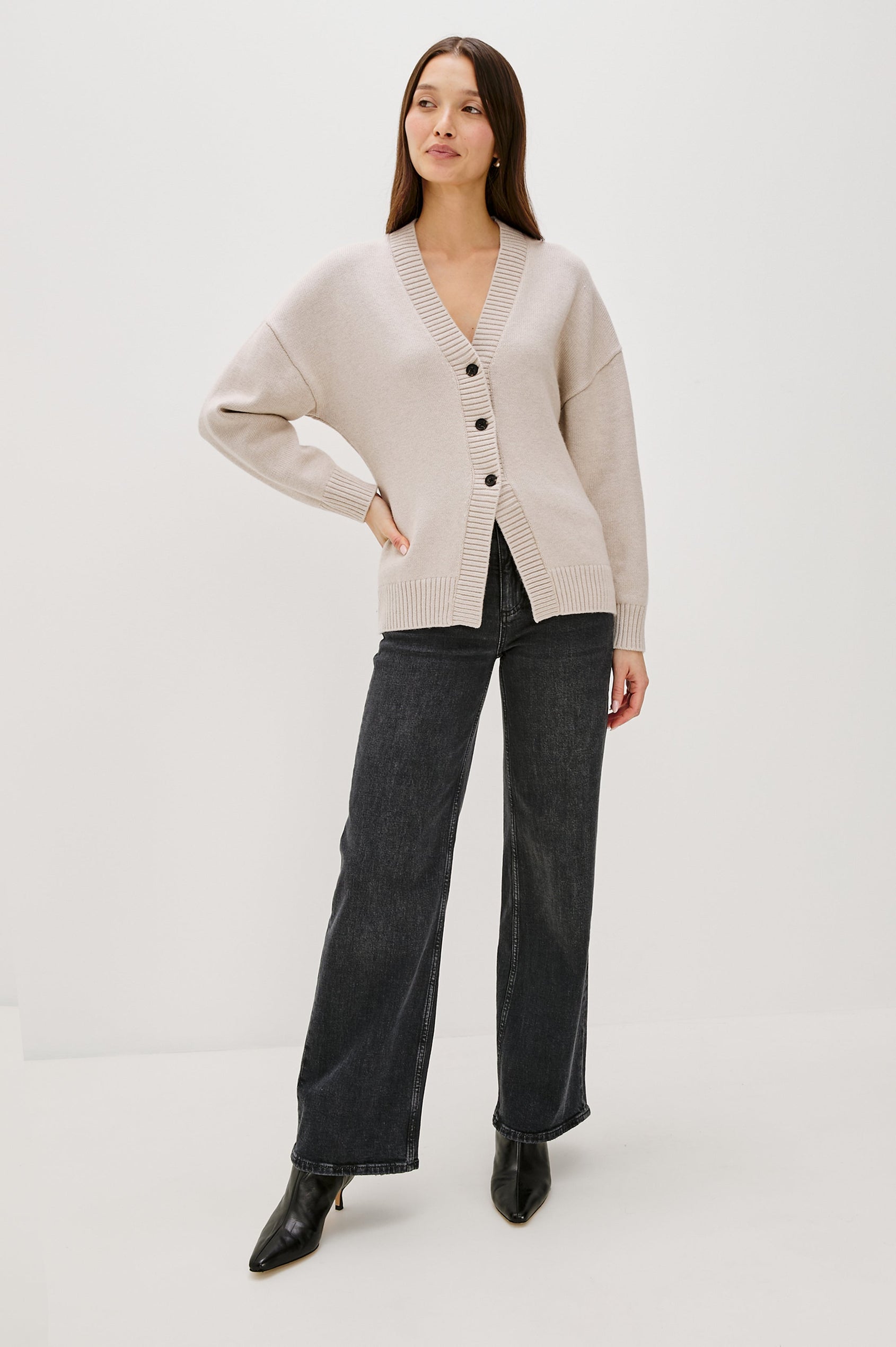 Longline cardigan in a cotton-wool blend in Taupe Colorway. The design features drop shoulders and a front cutaway detail, creating a soft, relaxed, and flattering silhouette. Full Body Front View on Model.