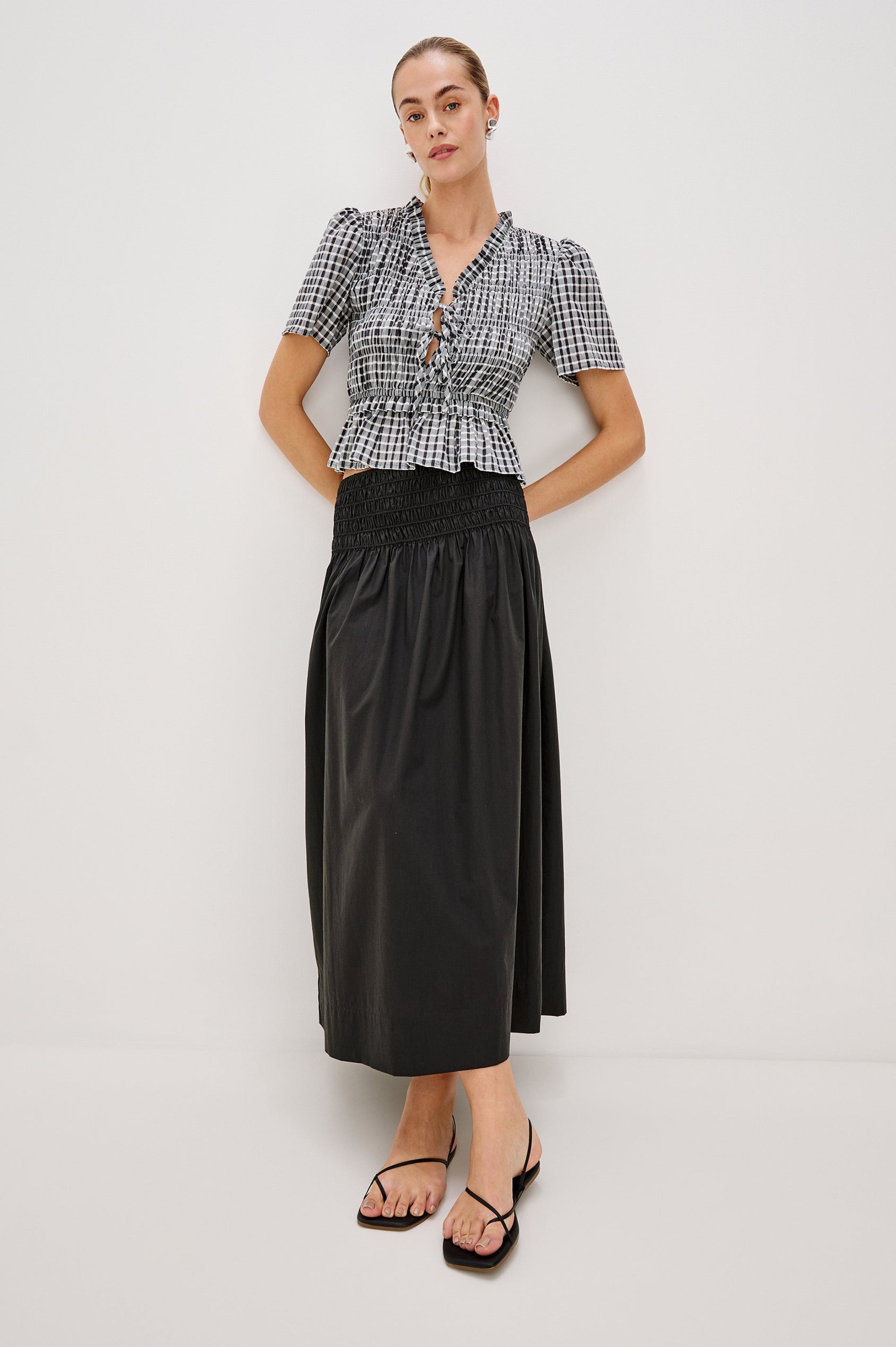 Portia V-Neck Tie Front Top with Short Puff Sleeves and a Ruffled Peplum Hem in Ash Seersucker Colorway. Full Body Front View Shown on Model.