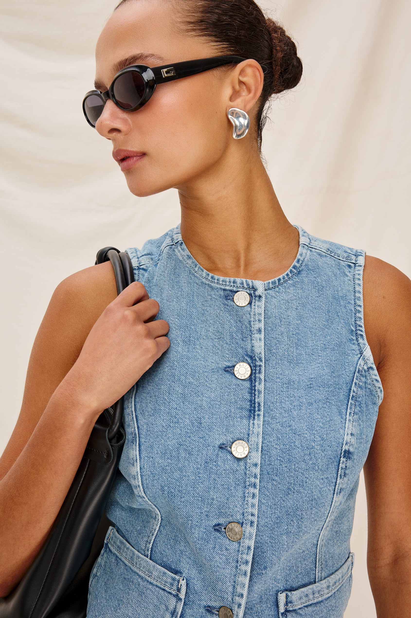 Portola Sleeveless Denim Vest with Exposed Button Front Closure, Crew Neck, Front Patch Pockets and a Scalloped Split Hem in Blue Eyed Girl Colorway. Full Body Front View Shown on Model.