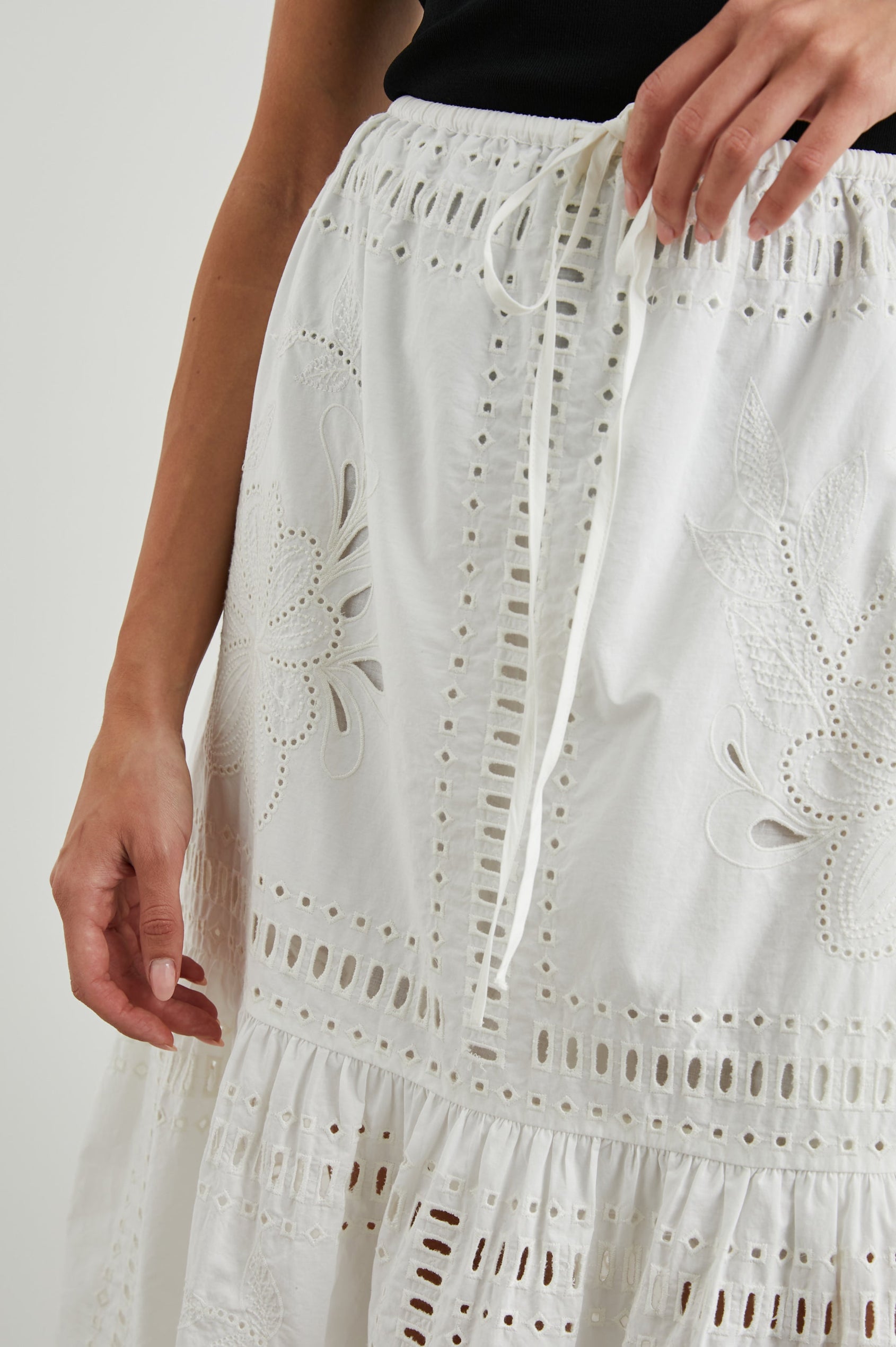 Prina Tiered Midi Skirt with a Drawstring Waist and Floral and Geometric Eyelet Details in White Colorway - Front View Featured on Model