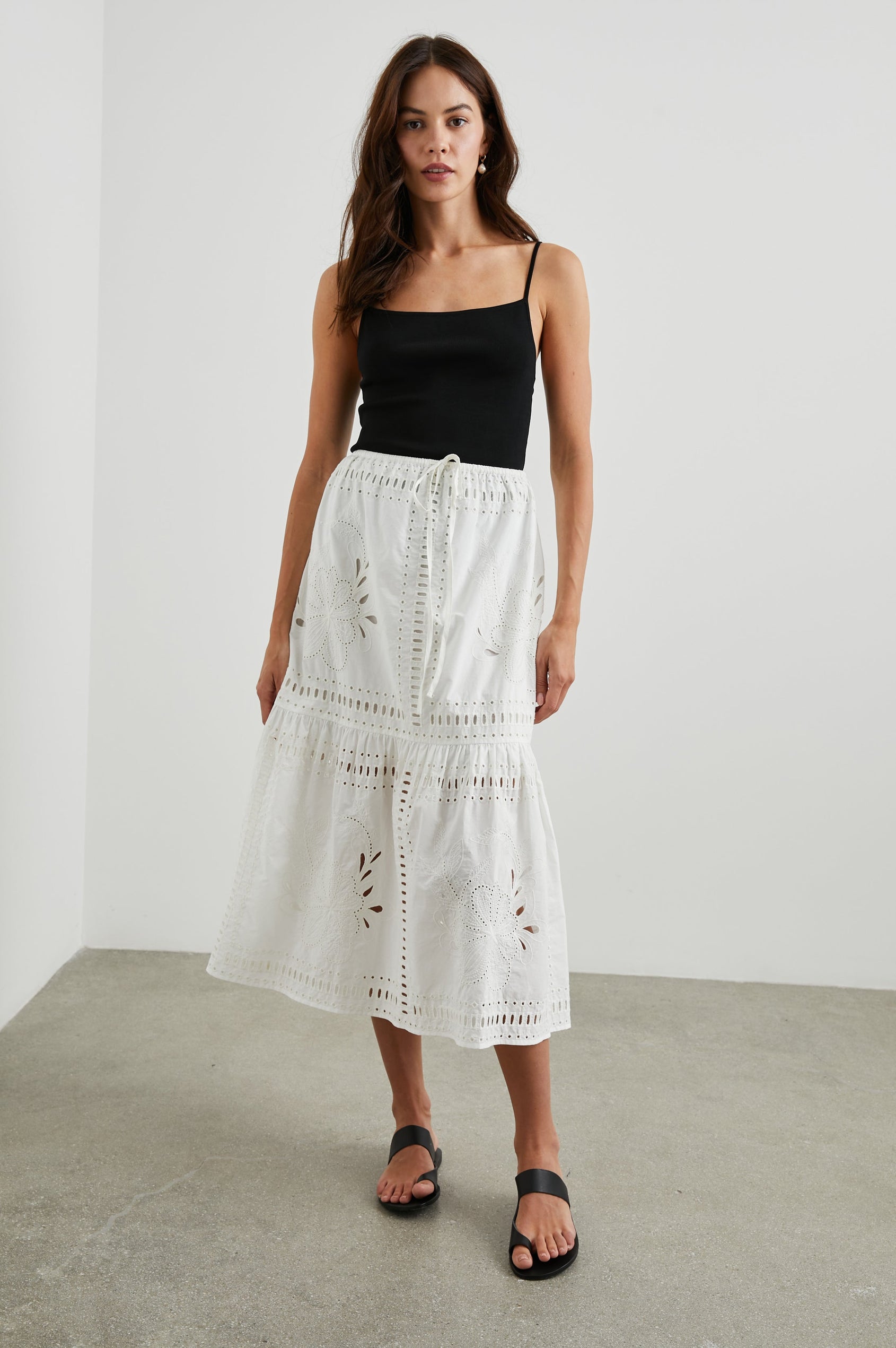Prina Tiered Midi Skirt with a Drawstring Waist and Floral and Geometric Eyelet Details in White Colorway - Front Full Body View Featured on Model