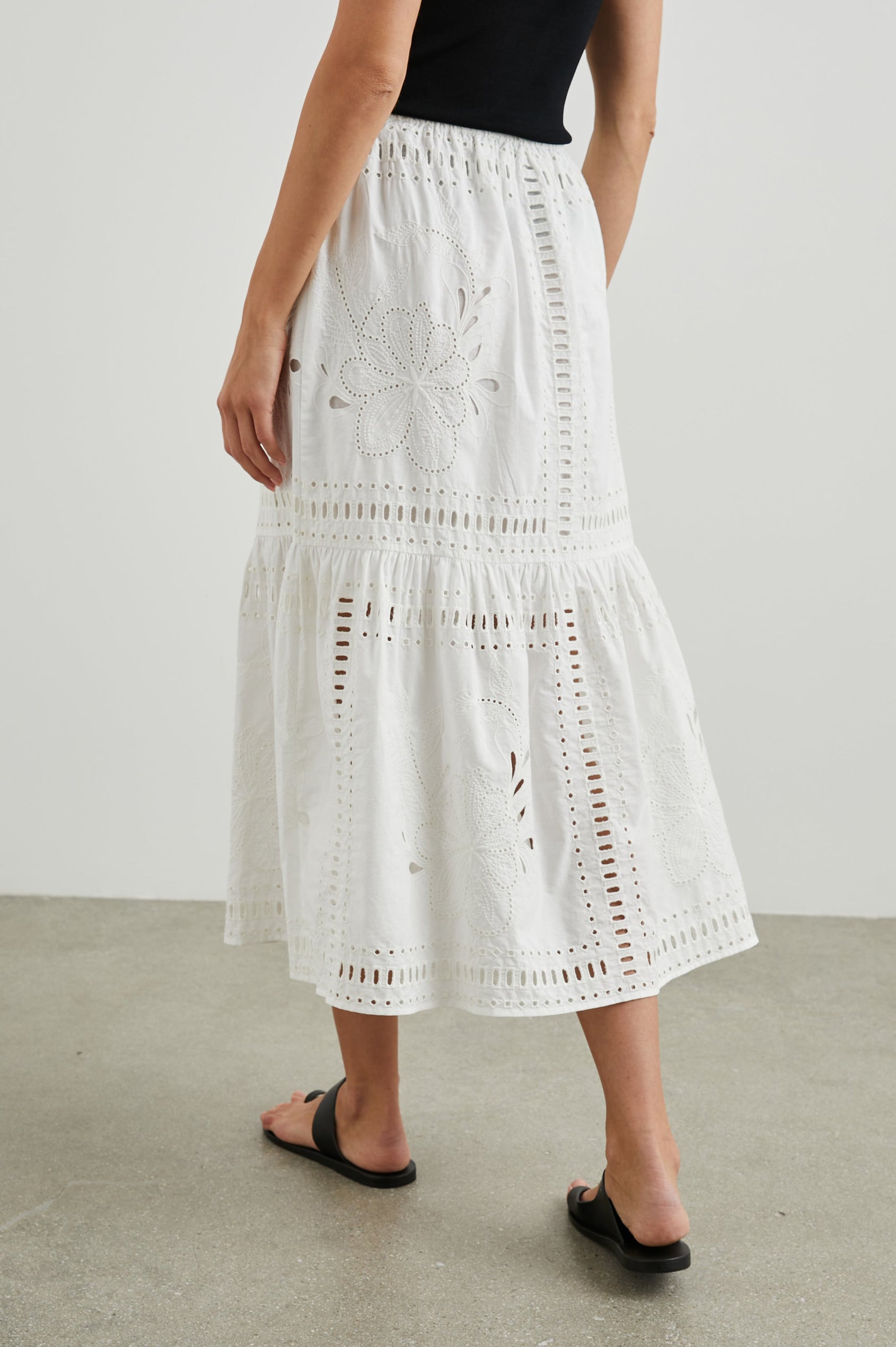 Prina Tiered Midi Skirt with a Drawstring Waist and Floral and Geometric Eyelet Details in White Colorway - Back View Featured on Model